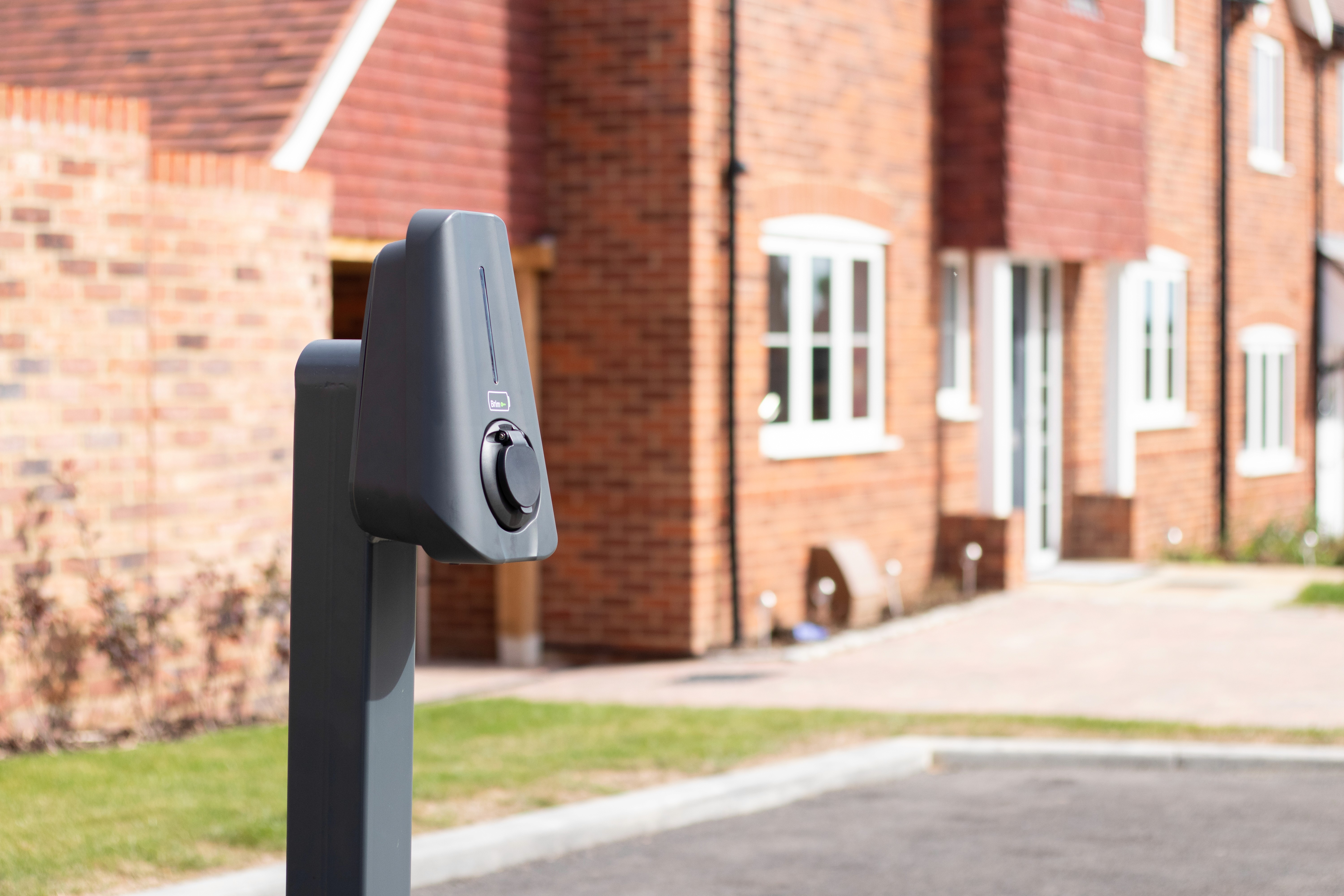 Close up of Brim Smart EV Charger infront of a gravel path on a British countryside new build site