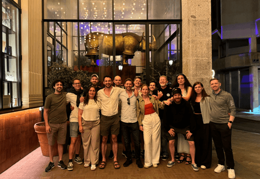 The Rhino.fi team standing together during an evening event in front of a lit-up venue