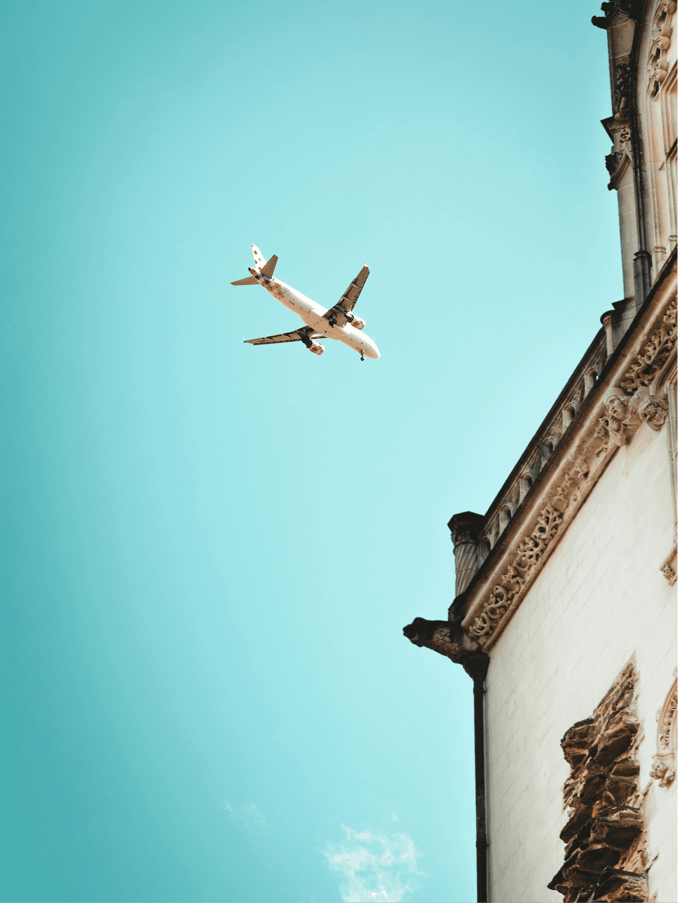 an airplane flying in the sky over a building