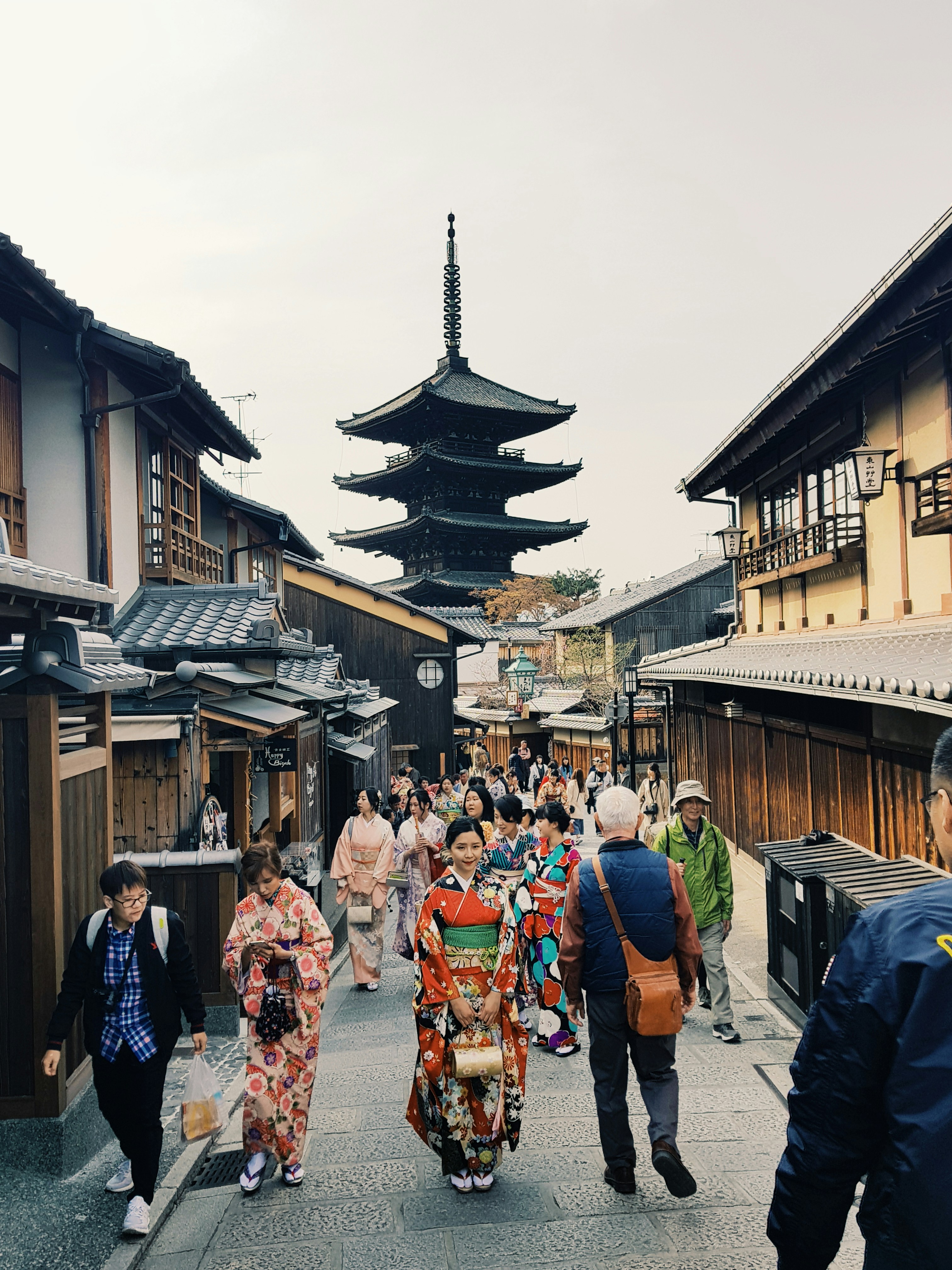 people walking along road leading to a pagoda