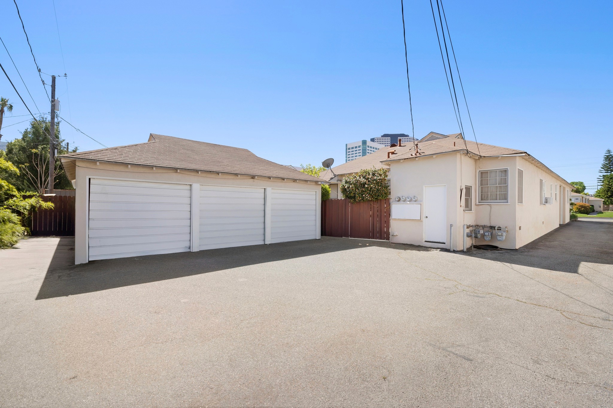 Rear parking area with detached garages and paved lot at 242 N Cordova multifamily property.