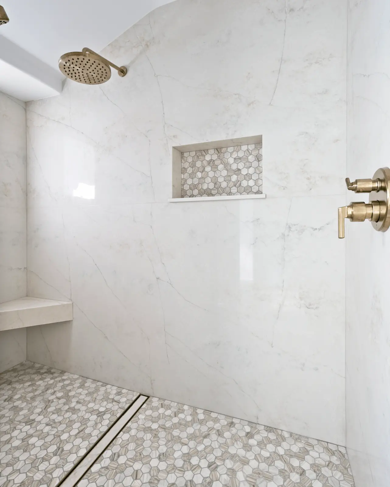 Portrait of the primary bathroom's luxurious shower, highlighting the spacious design and modern fixtures in the Ladera Ranch Remodel. Photo by Todd Huge.