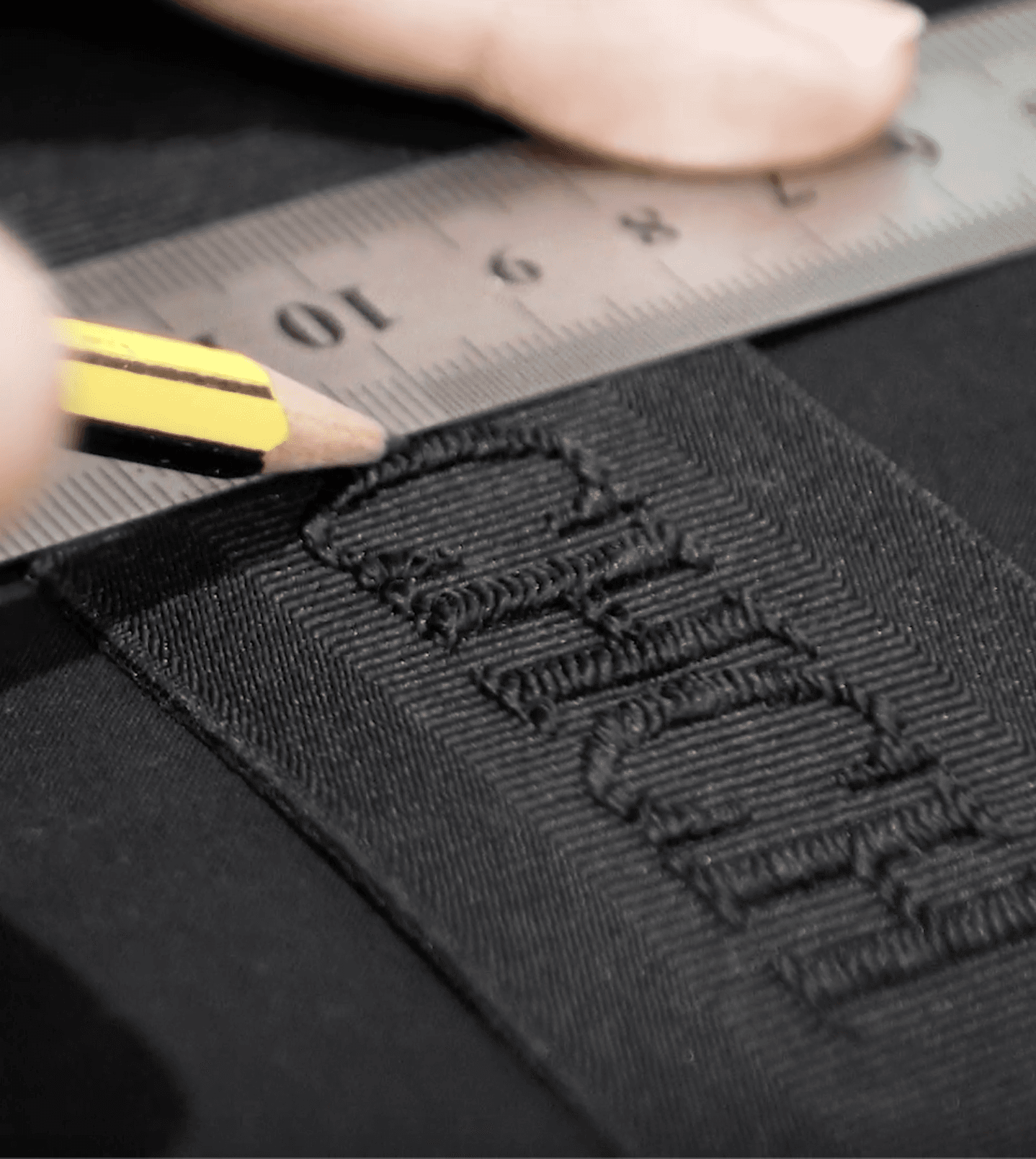A person holding a pencil measuring a detail from Carolina Herrera fashion production piece - Fashion Management Production - Savart Agency