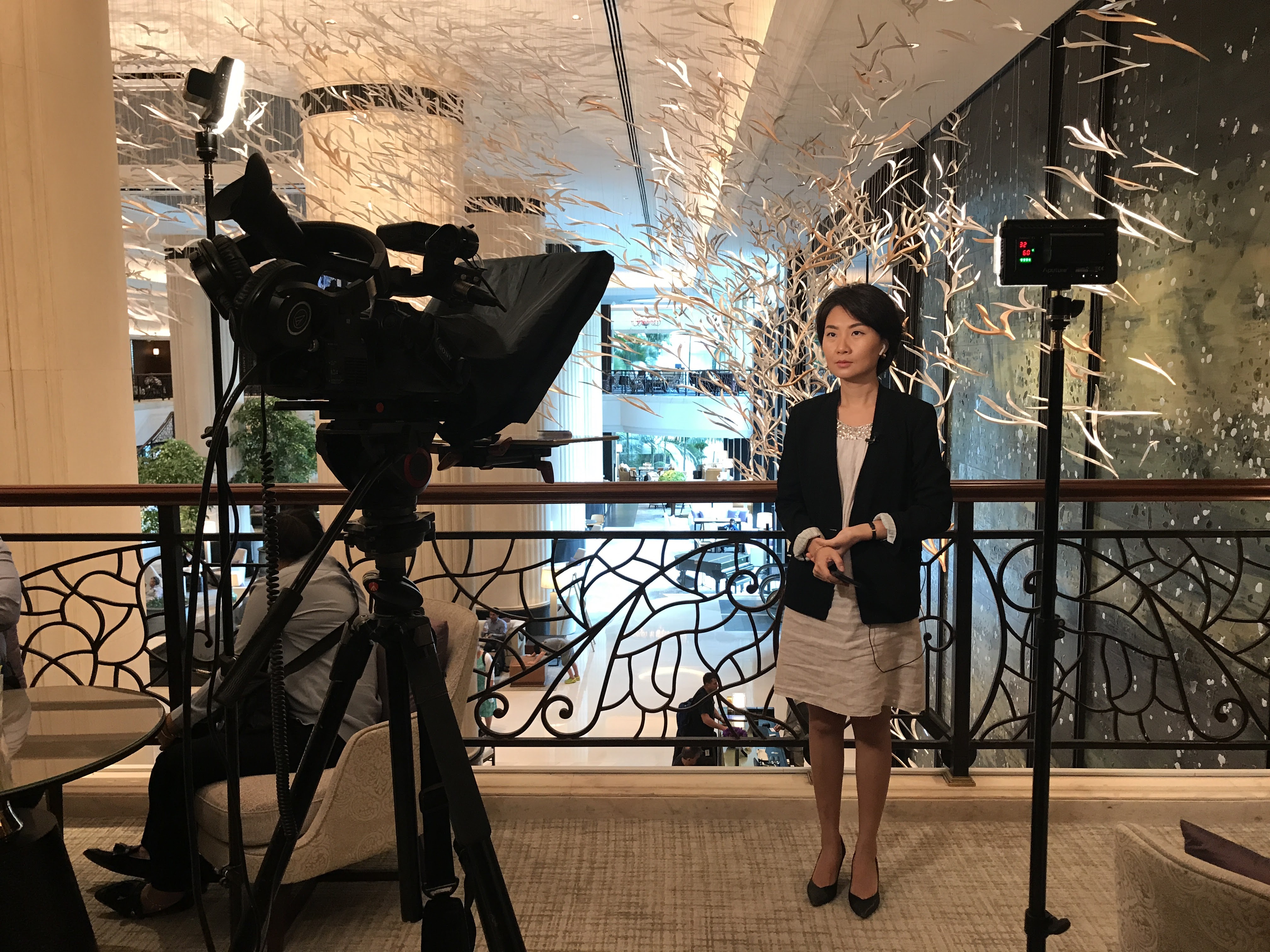 man in black polo shirt wearing white mask holding black camera