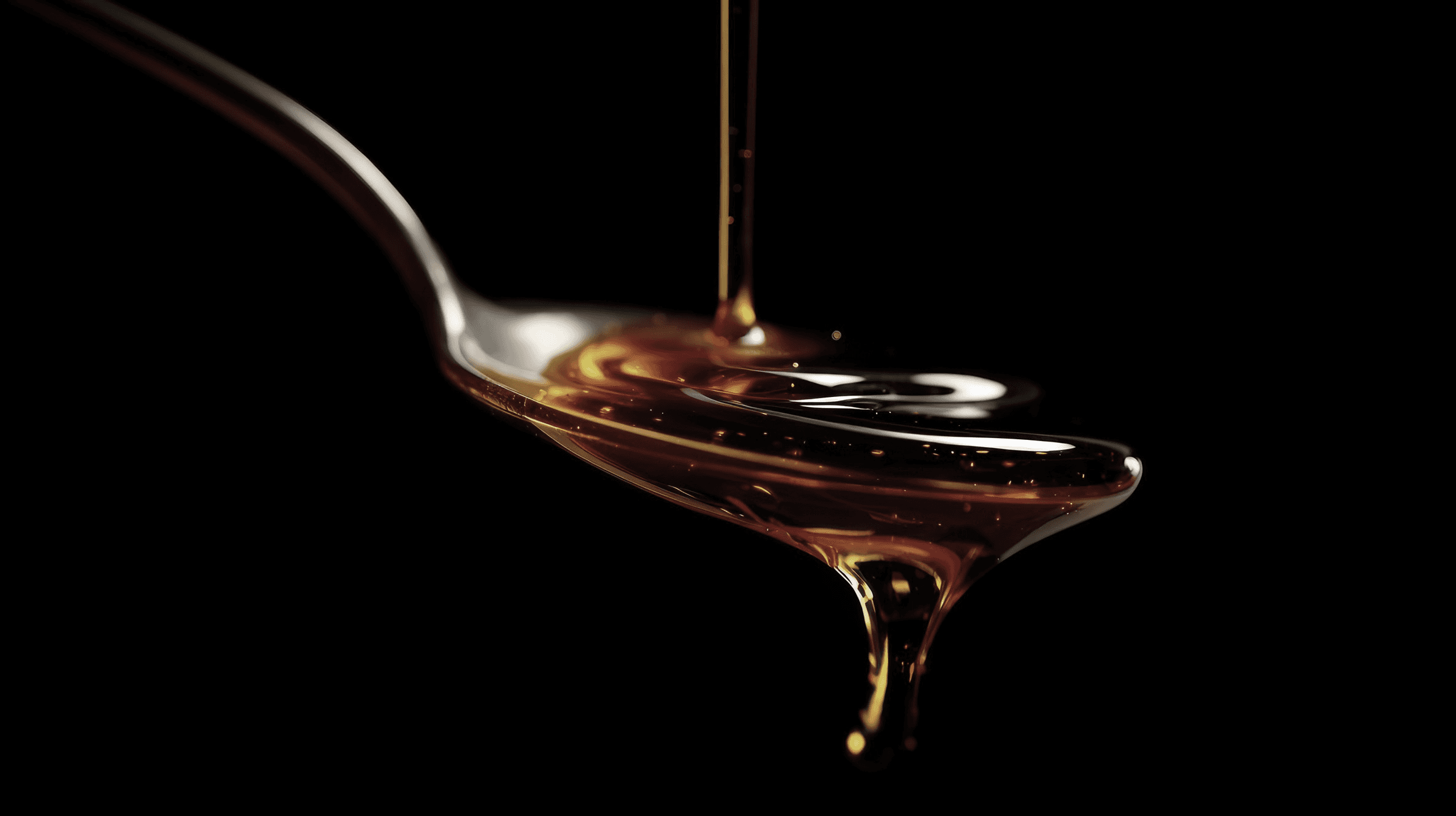 Golden sugar syrup representing activated carbon purification for food and beverage processing.