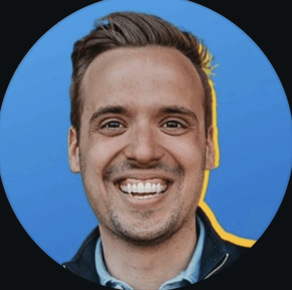An Asian man wearing a formal suit and tie, standing confidently with a neutral expression.
