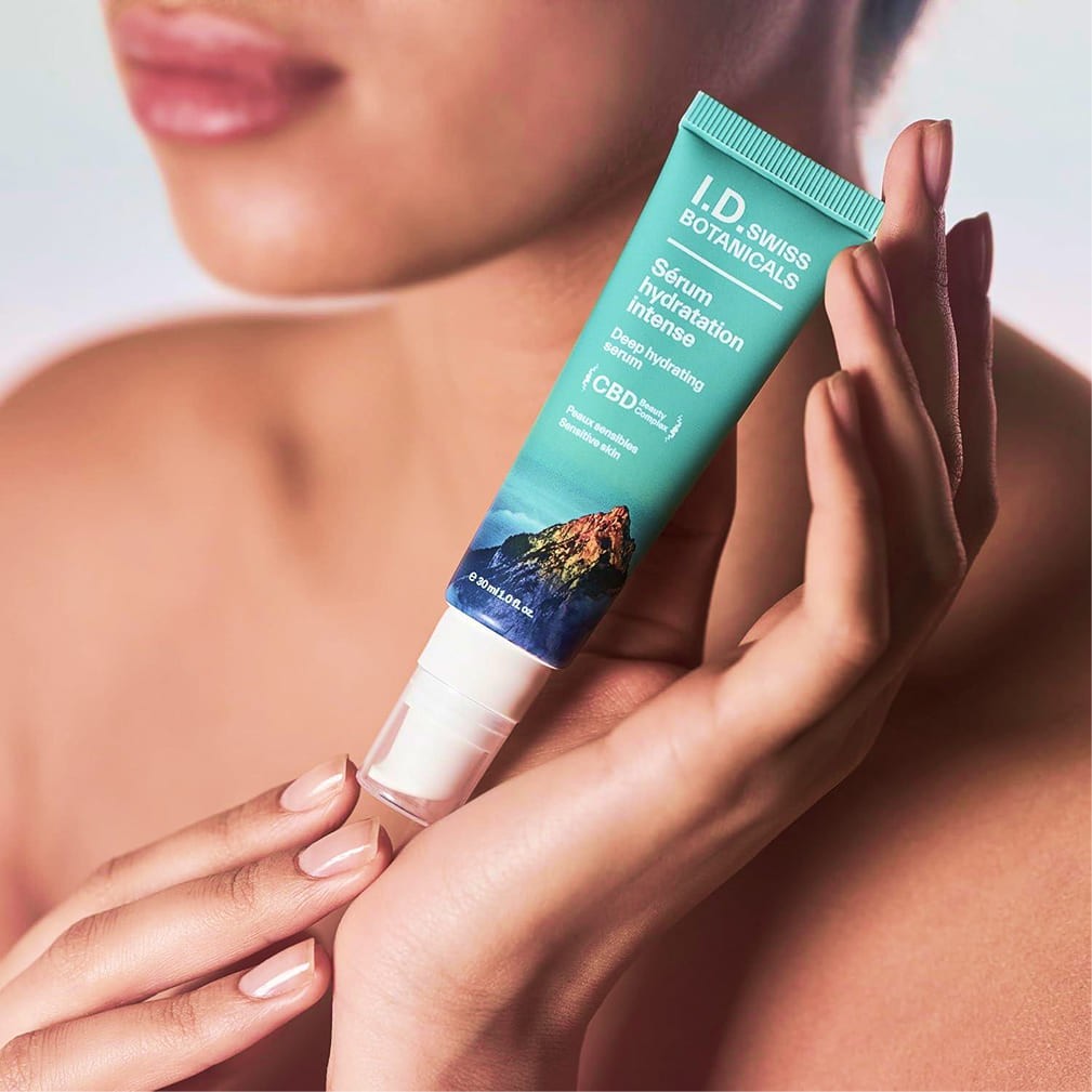I.D. Swiss Botanicals hydration serum held by model highlighting premium skincare product and natural glow