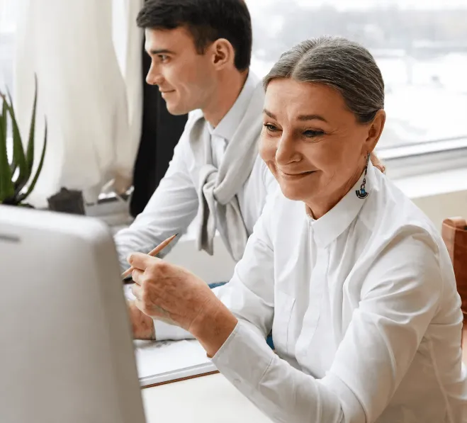 Business professionals using instant bank transfer software to manage vendor payments in an office.