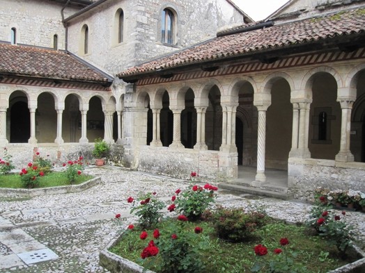 A photo of an old stone buildings with arches and pillars.
