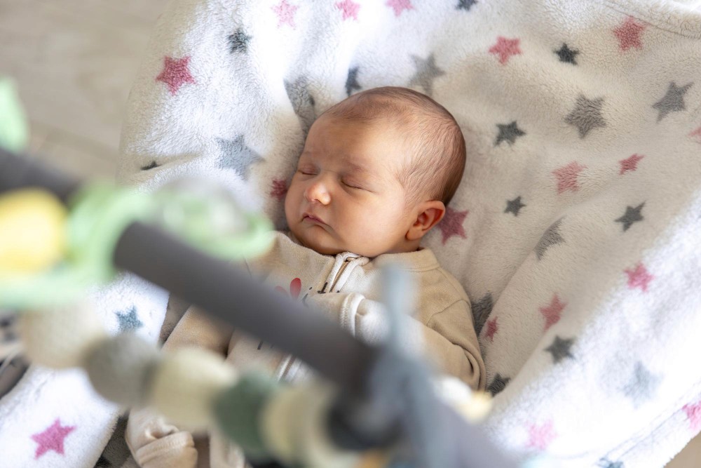 Baby sleeping peacefully in a bassinet for a newborn hospital photo.