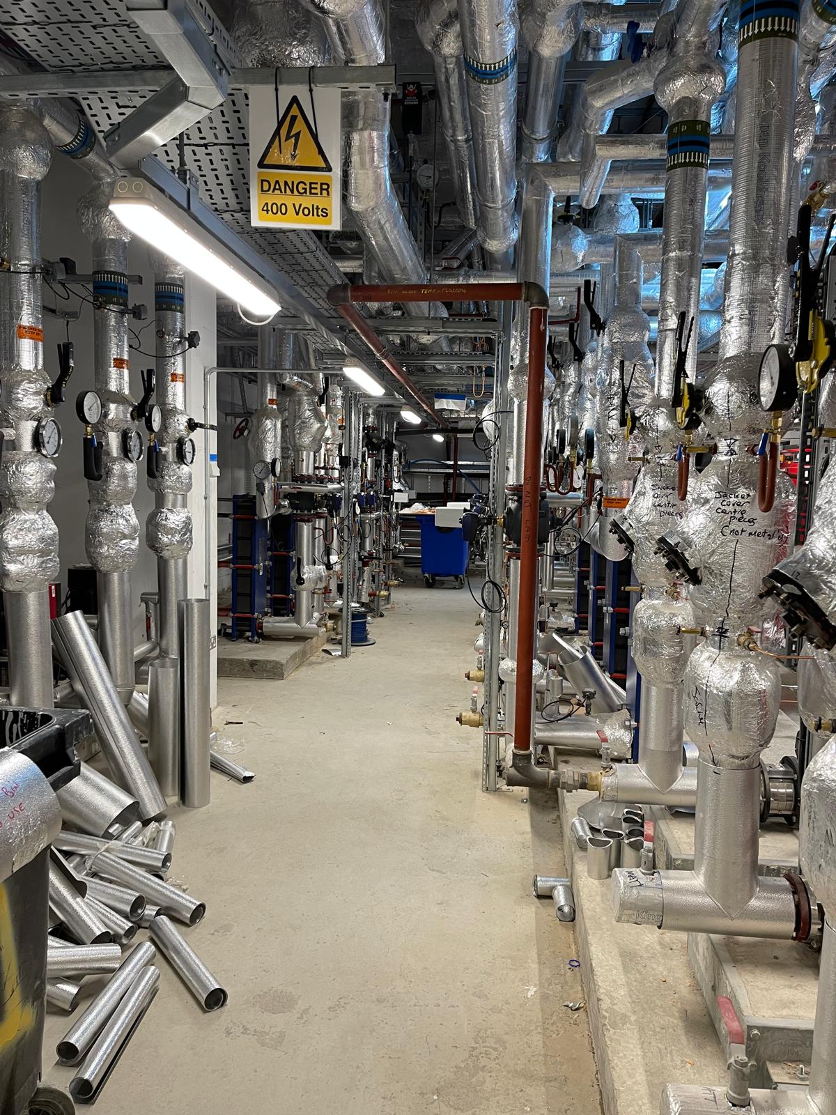 Completed commercial plant room corridor with installed pipework and services