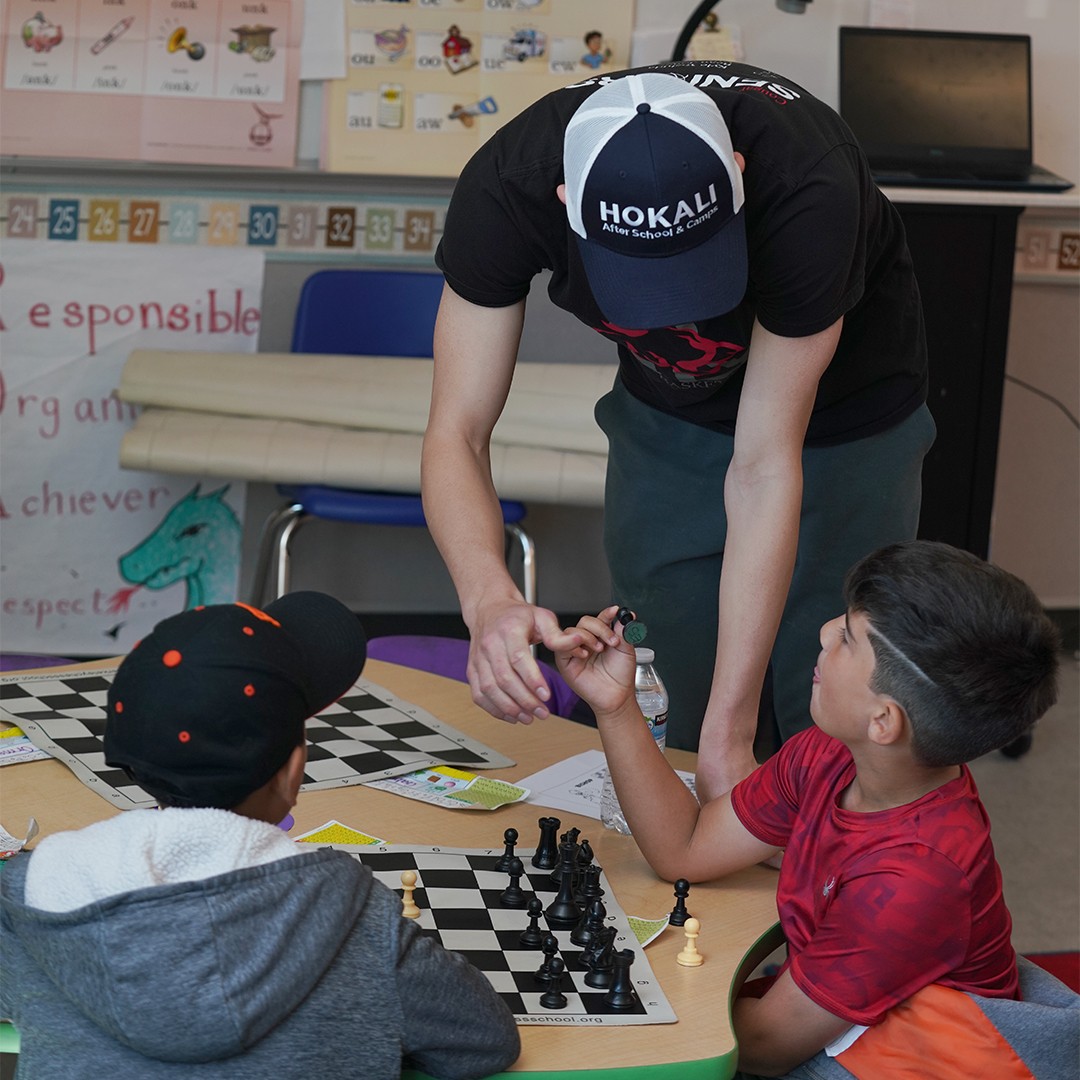 Students concentrating on competitive chess match during after school workshop