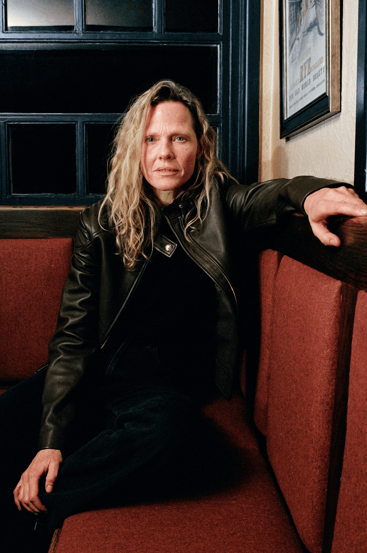 Une mannequin qui porte une veste biker de la marque Belstaff dans un pub