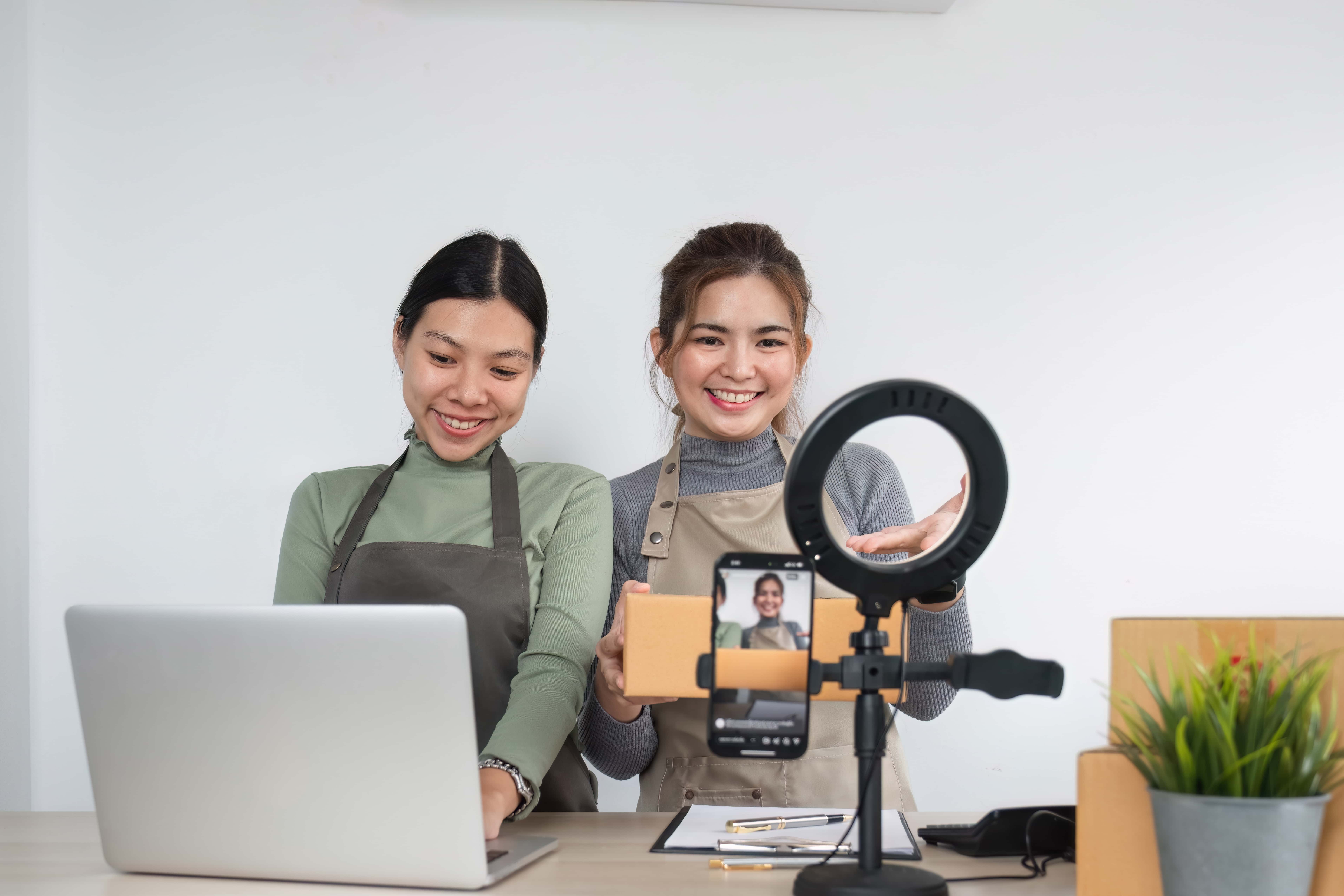 Two entrepreneur women take order and check boxes of products according to customer orders in