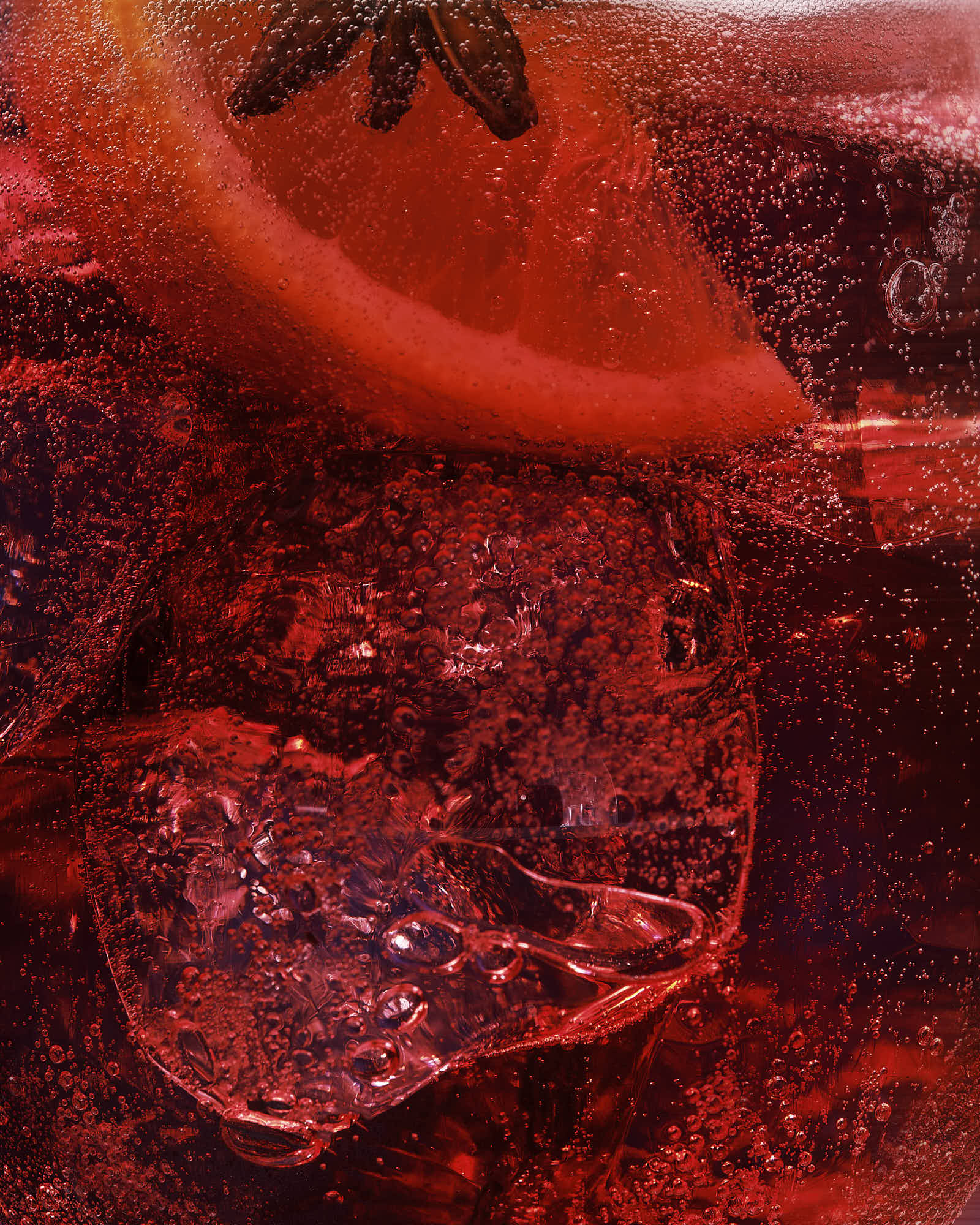 An abstract image with rich red hues and dark textures resembling layers of organic material.