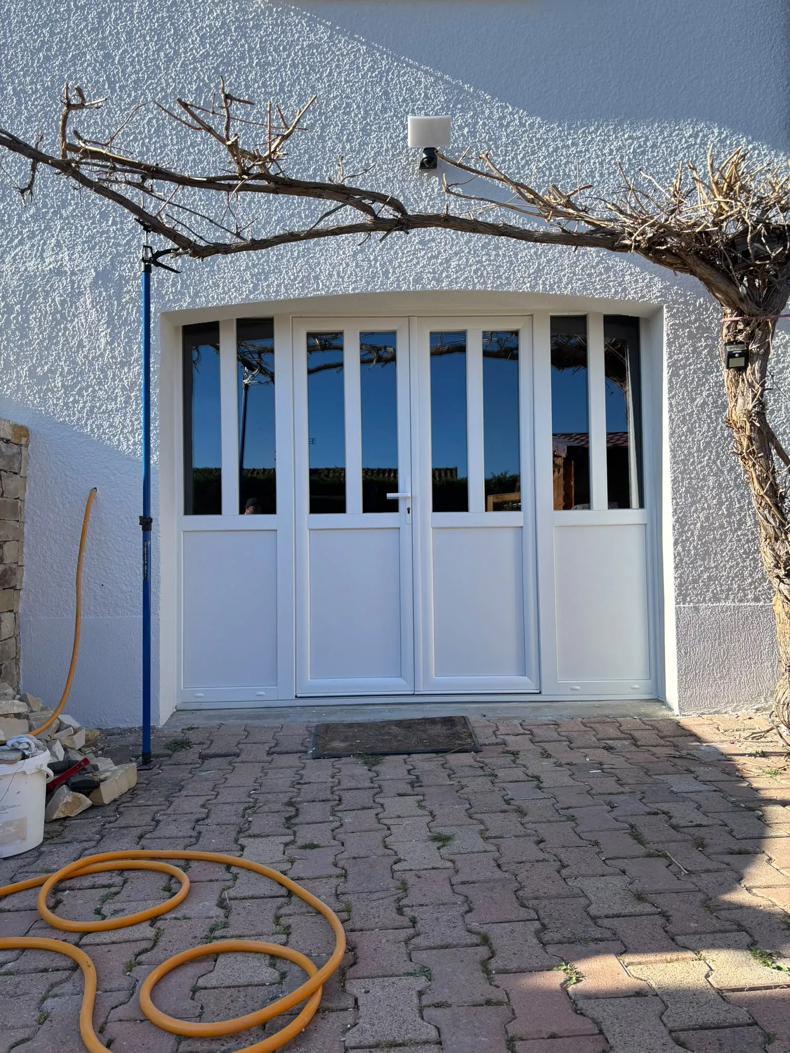 Porte de garage vitrée dans une façade en pierre — AFermetures