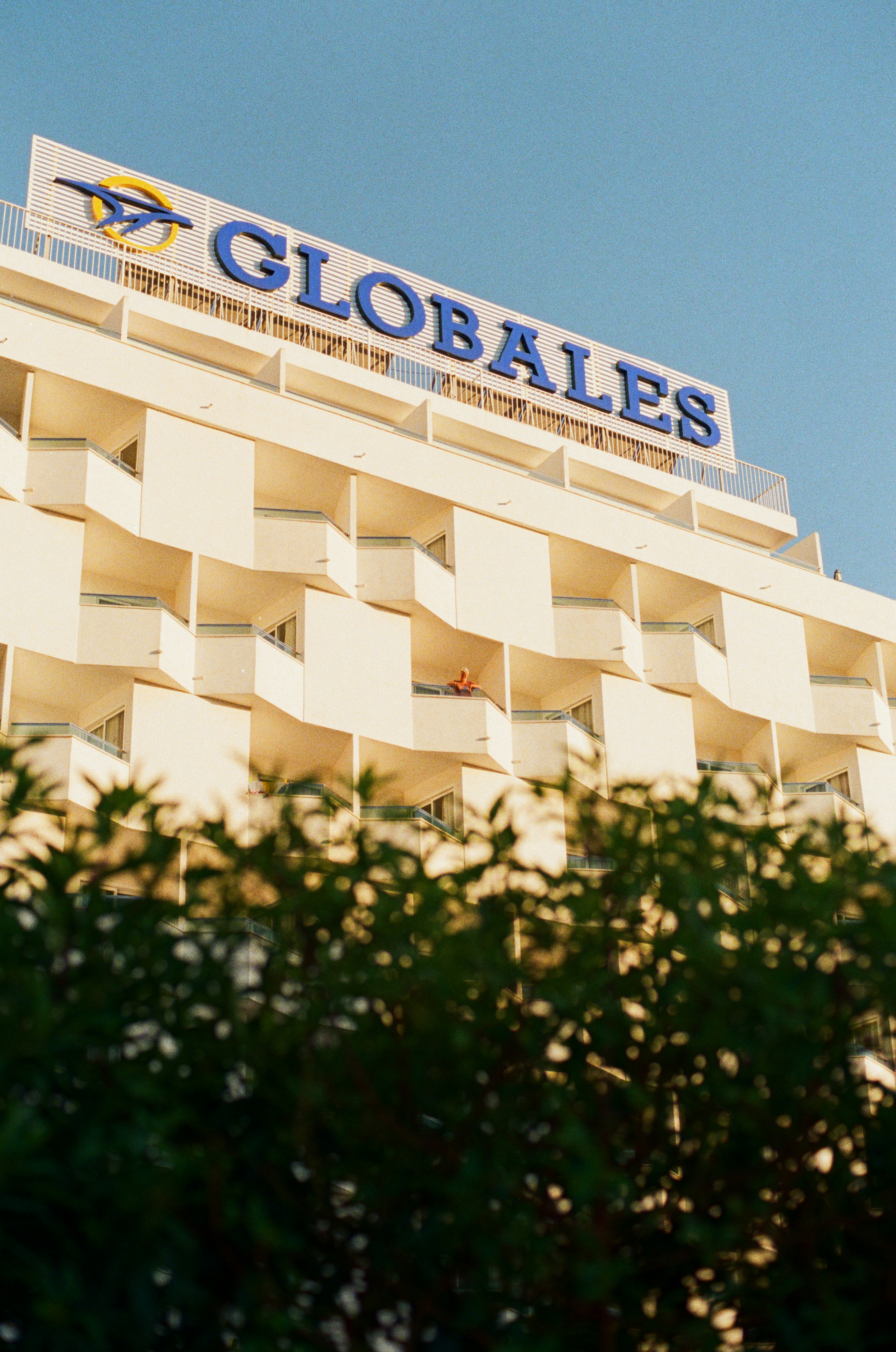 Modern hotel building with balconies against blue sky