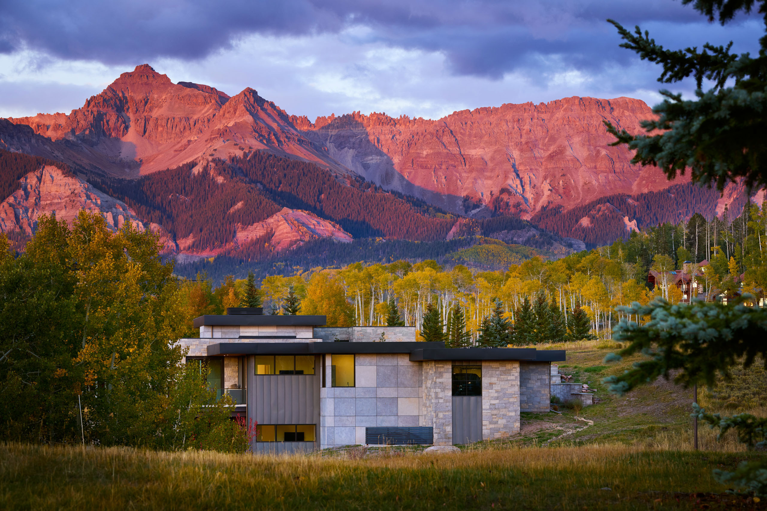 Modern house with mountains and autumn trees