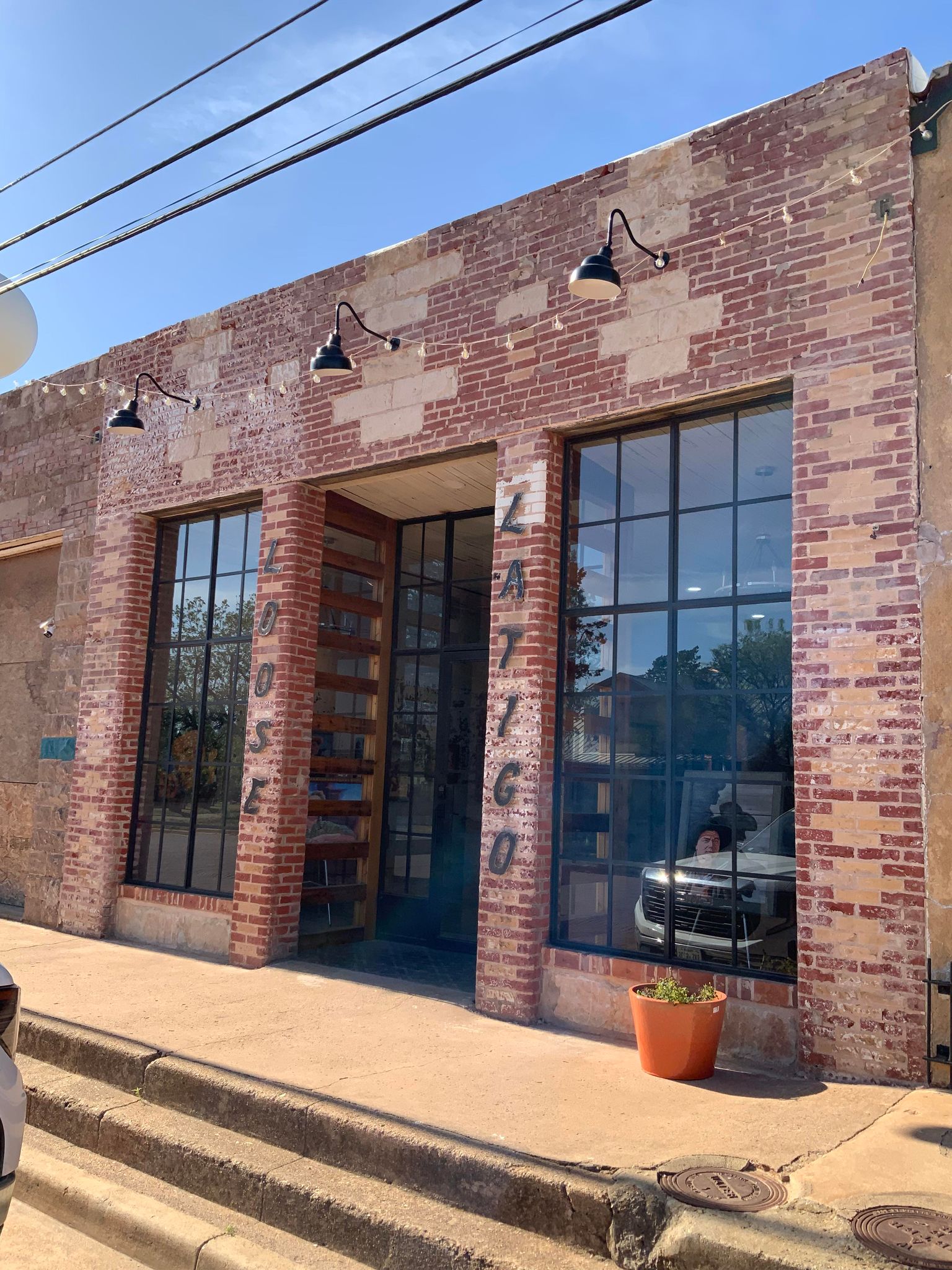 The front of the gallery with two very tall windows and a sign in metal lettering reading Loose Latigo