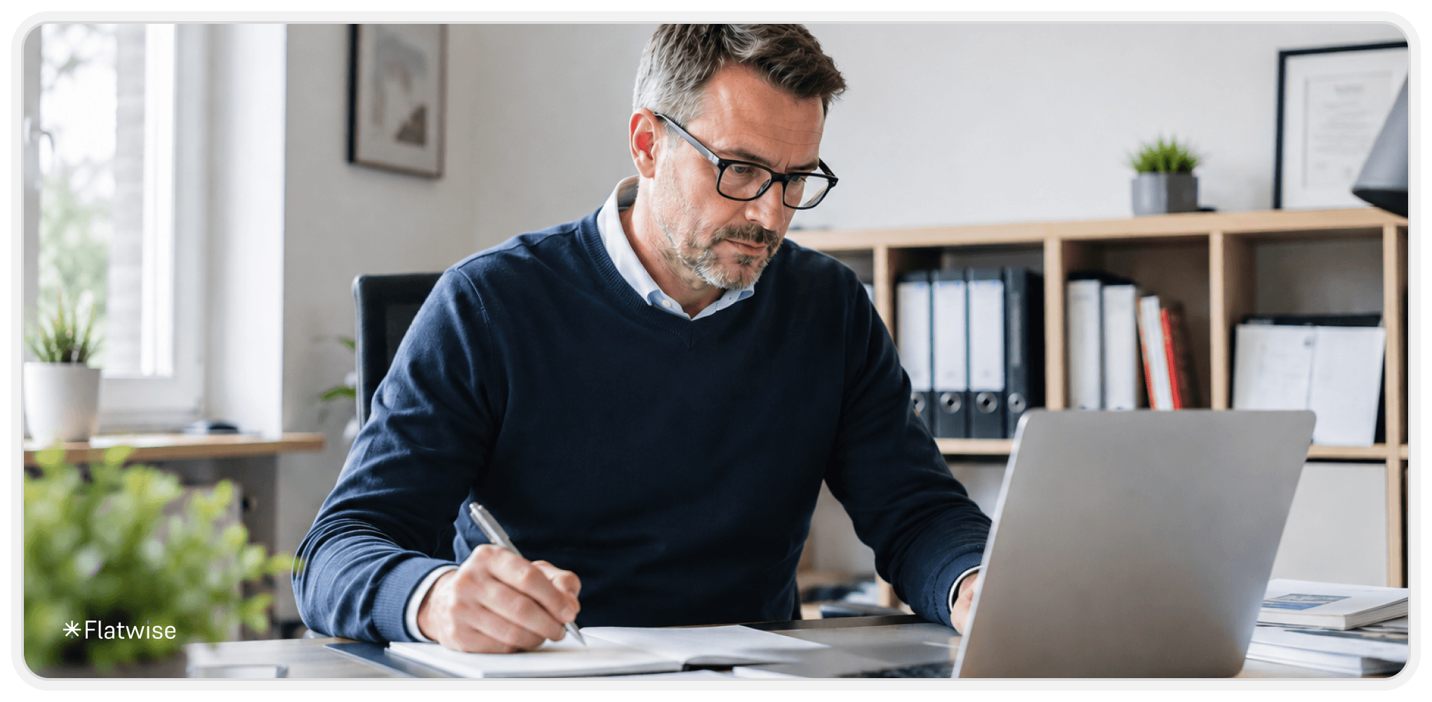 Professionelle Hausvertrauensperson sitzt an einem Schreibtisch in einem modernen Büro und bearbeitet Unterlagen am Laptop. Die Szene zeigt eine ruhige, helle Arbeitsumgebung mit minimalistischem Design.