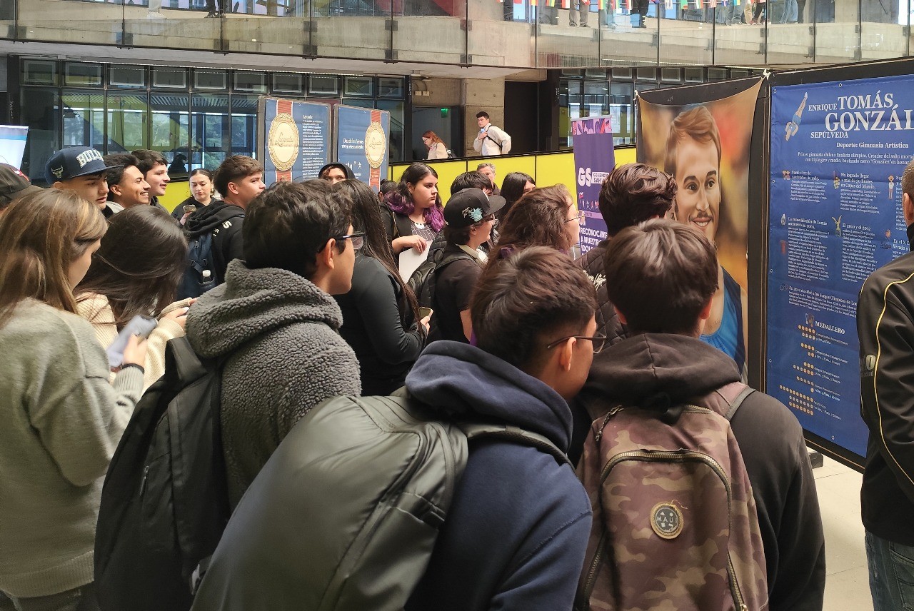 Espectadores contemplando la pintura de Tomás González, gimnasta chileno, en la exposición Leyendas del Deporte en USACH.