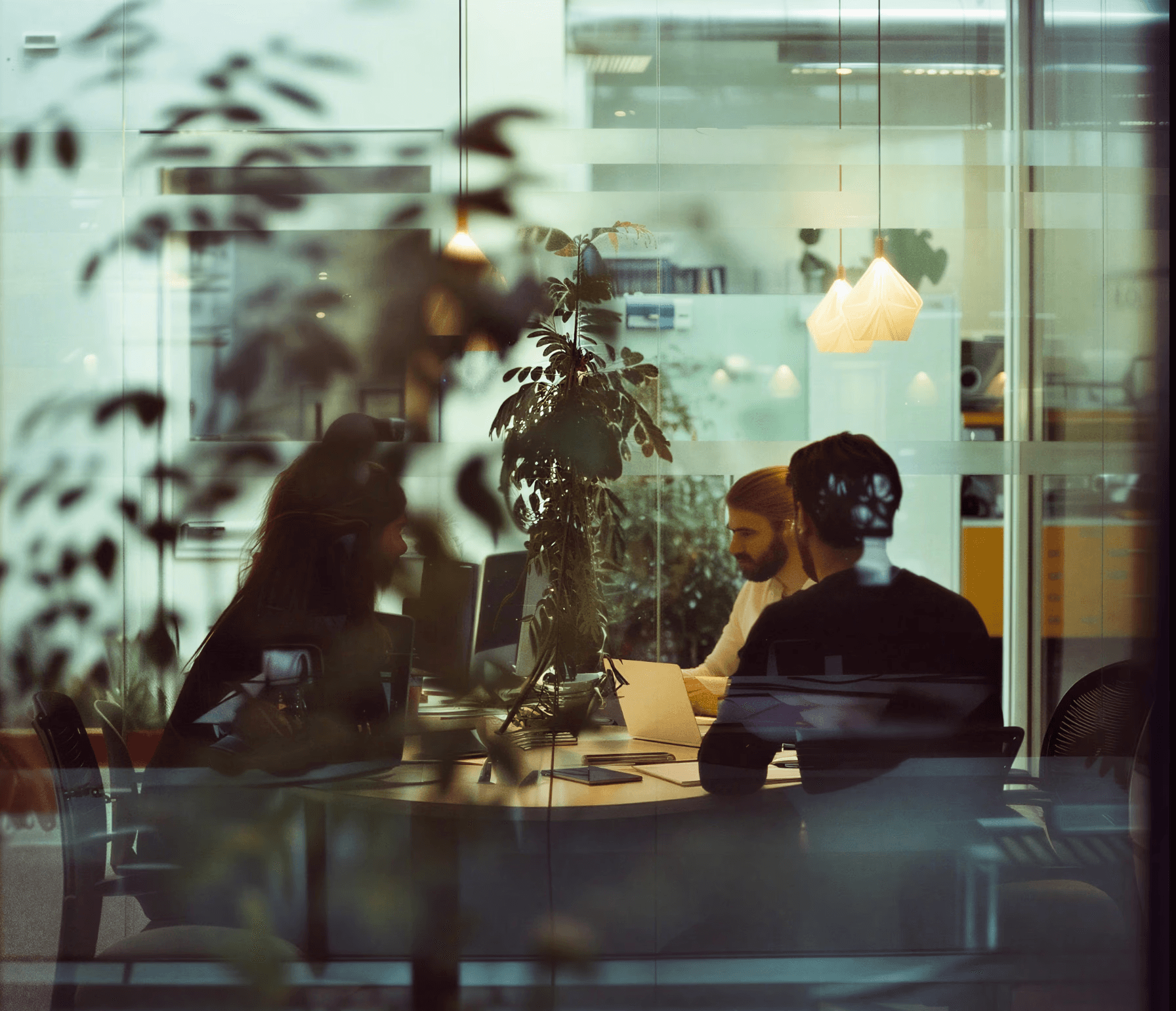 An Image of a team discussing in a glass walled space