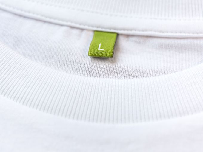 Dynamic close-up of a runner’s feet in motion, wearing white running shoes with pink accents, sprinting across a sunlit concrete track.
