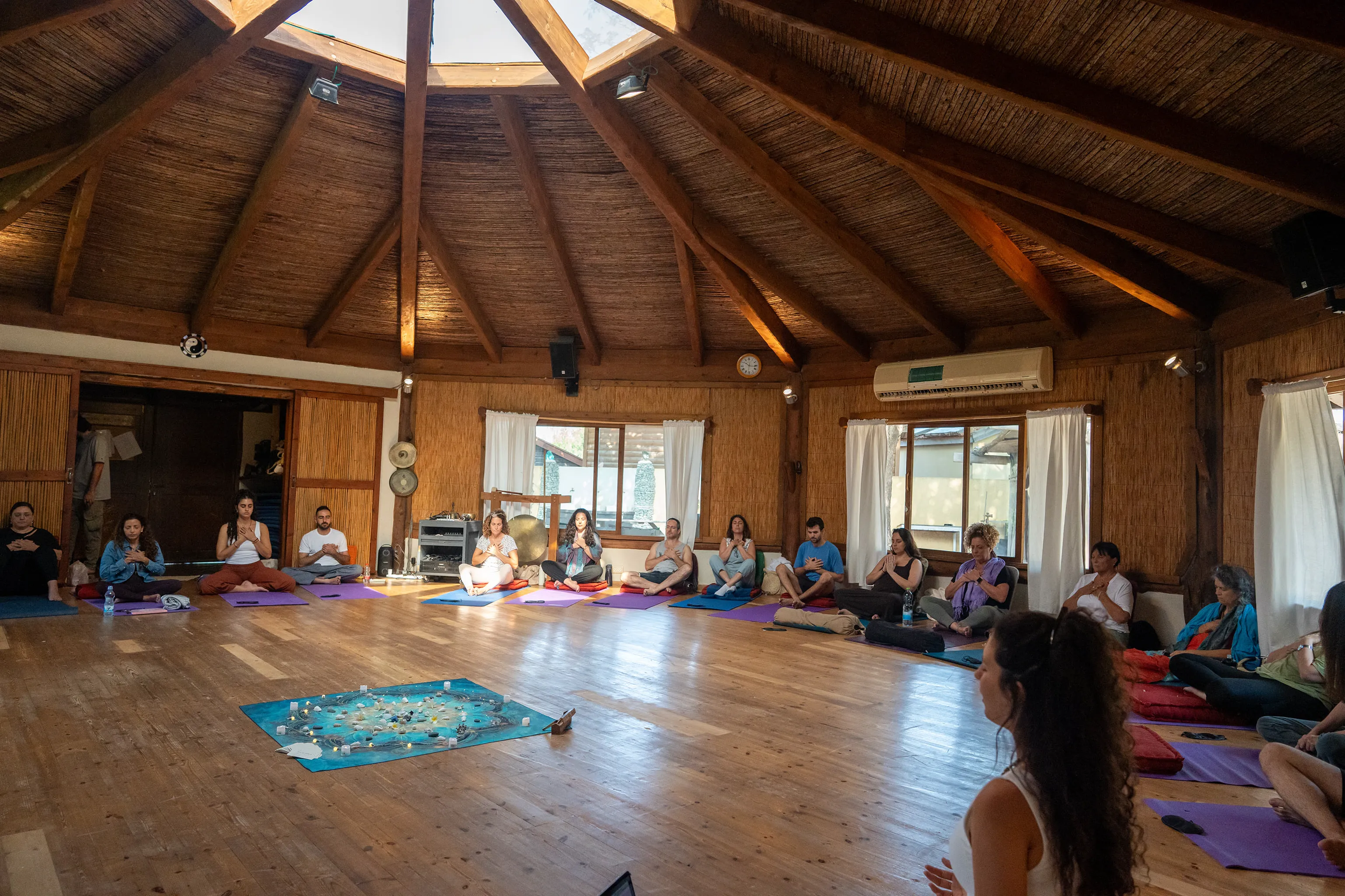 a circle of people seating in meditation position, in Gal's retrit