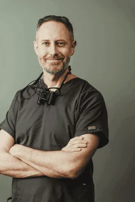 person in black leather shoes standing on yellow leaves