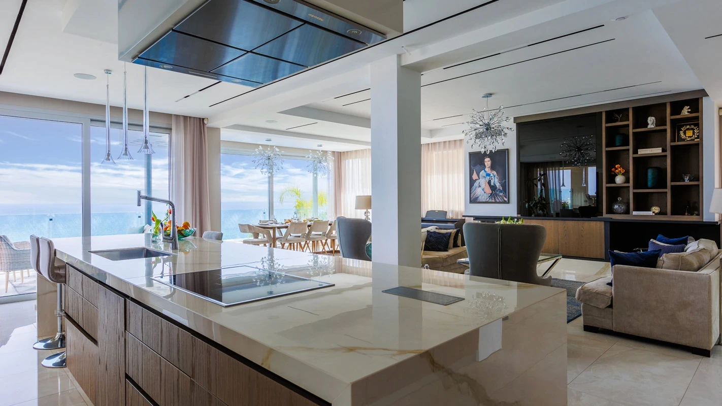 Seafront Residence Limassol open-plan kitchen with marble island, pendant lighting, and living area beyond