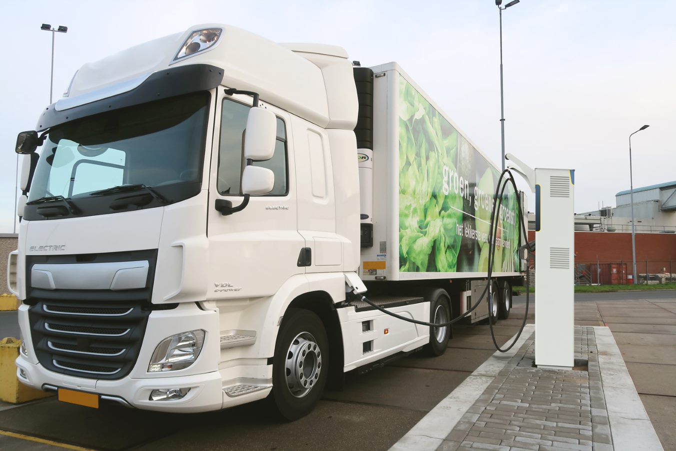 Electric truck charging at a station on a highway, illustrating the expansion of EU charging infrastructure.