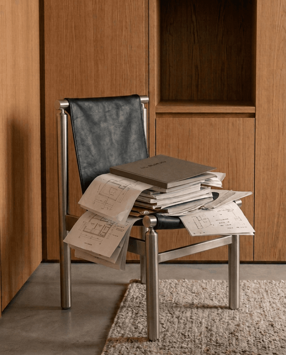 Black leather chair holding plans and a U.L. Bureau presentation folder