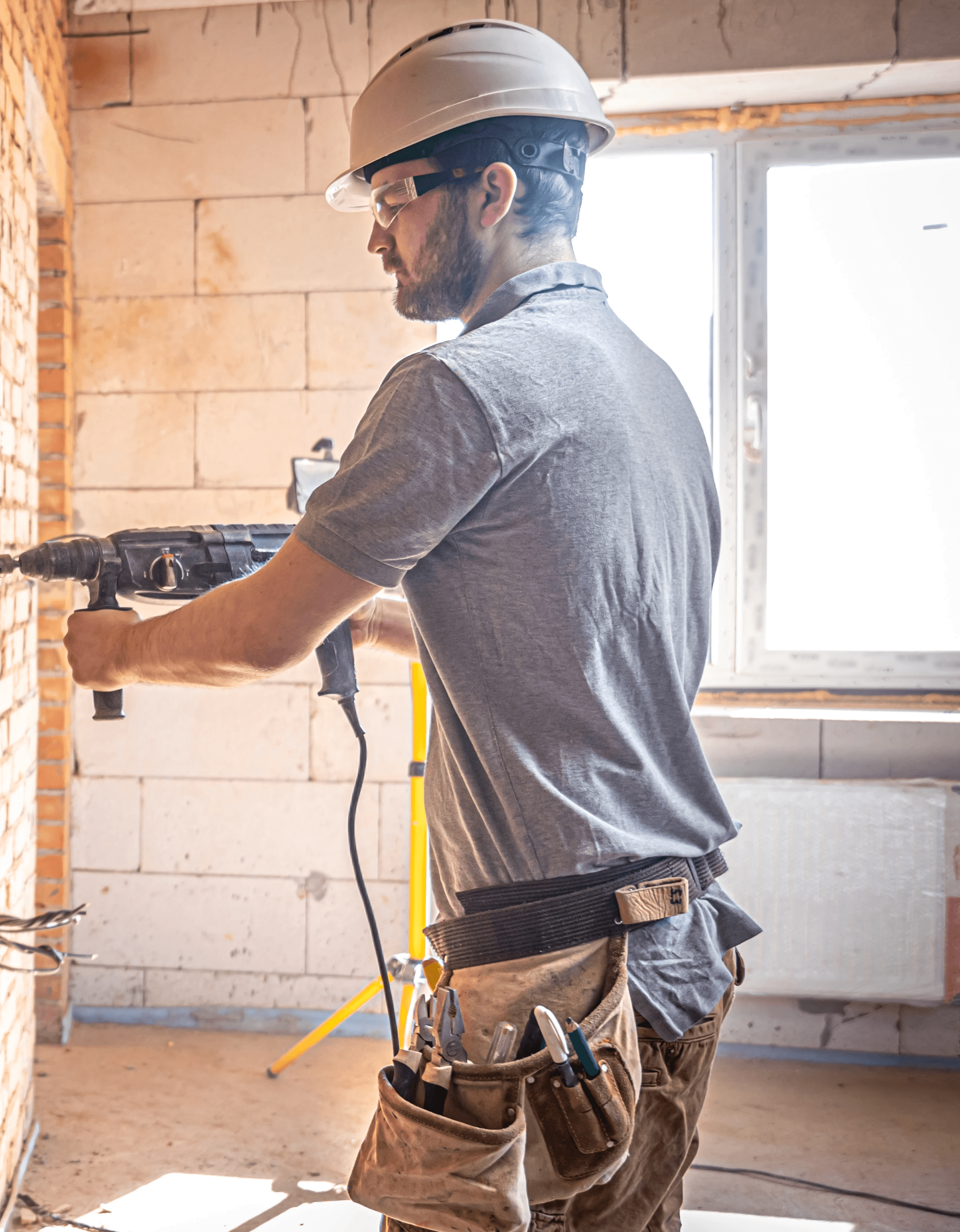 A smiling woman with her arms crossed, standing against a dark green background. She has long, dark hair.