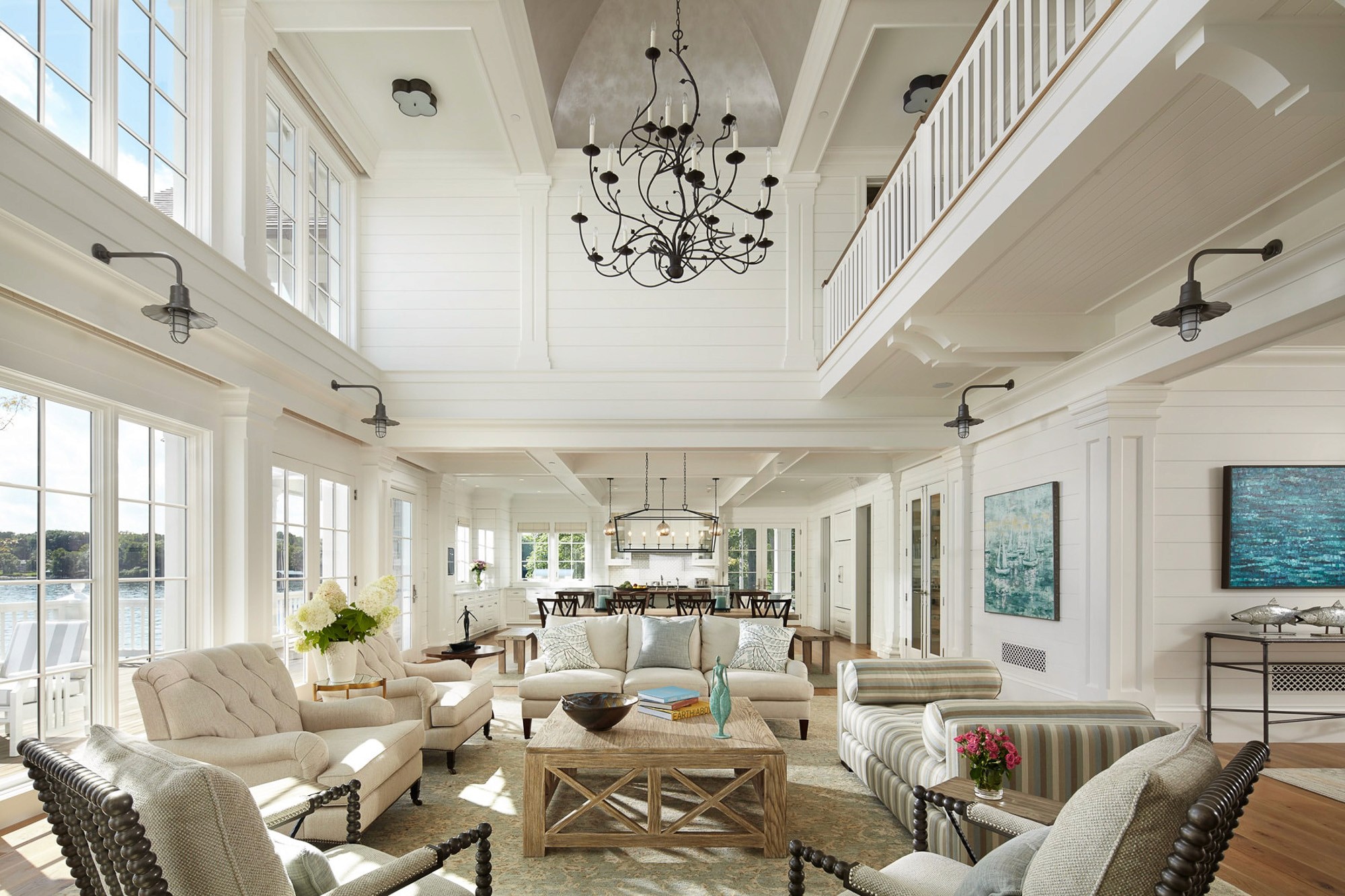 Bright waterfront great room and kitchen with high vaulted ceiling and lake views.