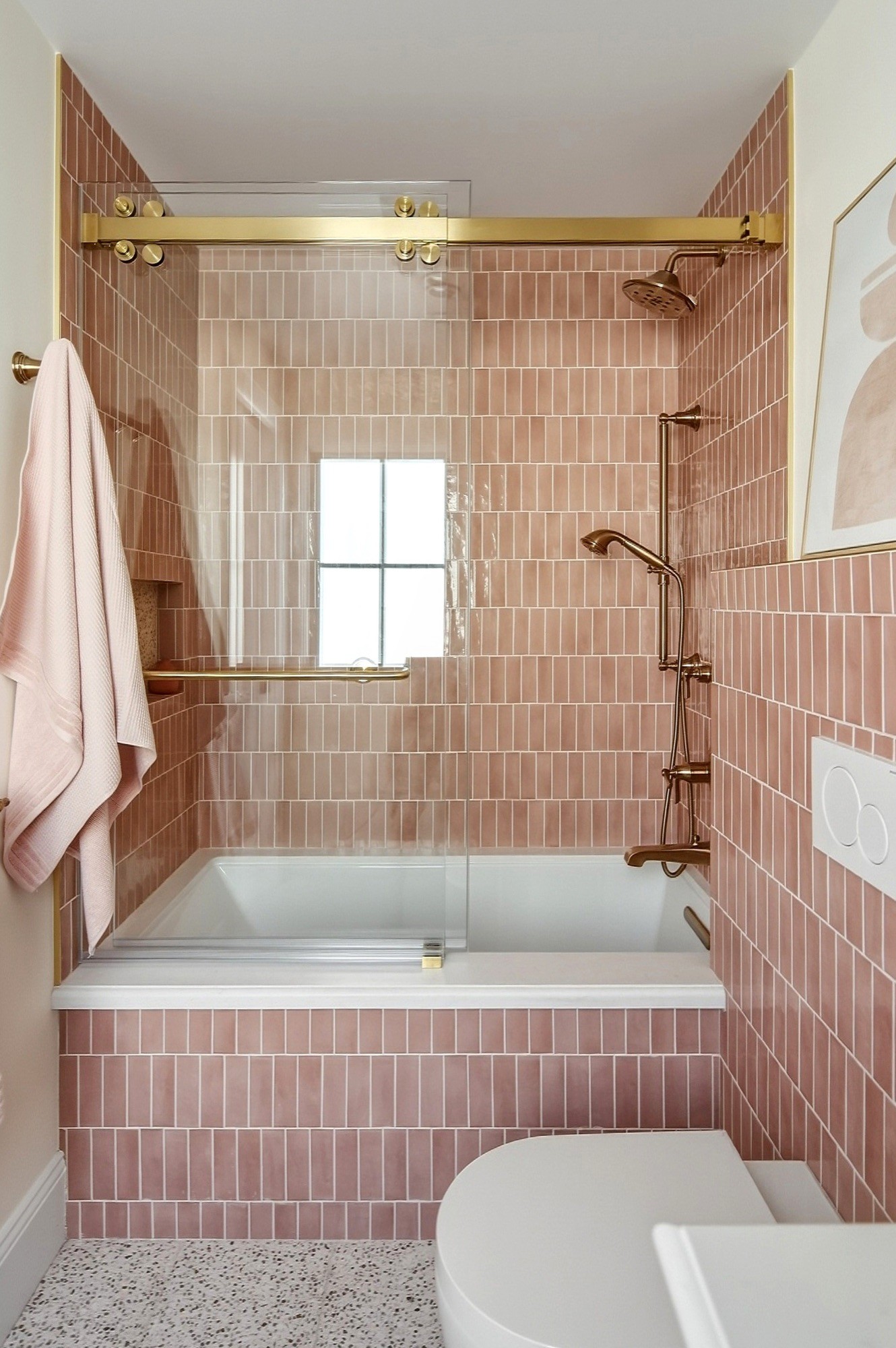 Bathroom with vertical blush tile, a soaking tub and a brass sliding shower rail