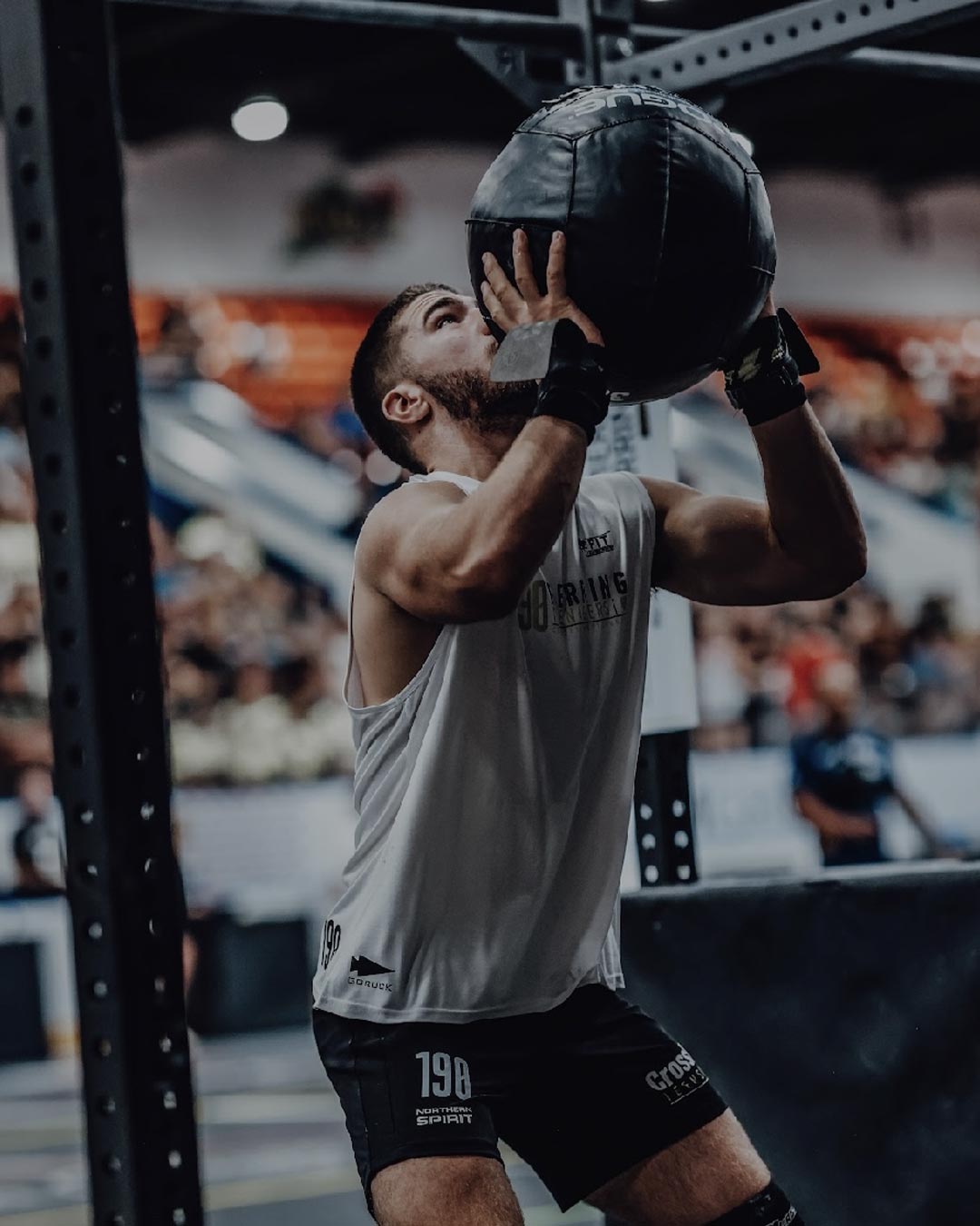 Two individuals are working out in a gym, focusing on dumbbells and strength training equipment.