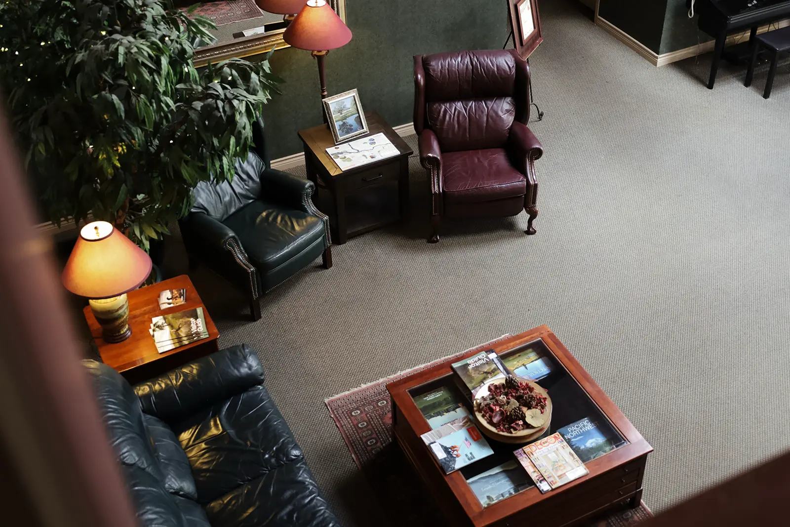 Hotel room with a four-poster bed, sofa, desk with a yellow office chair, and various lamps.