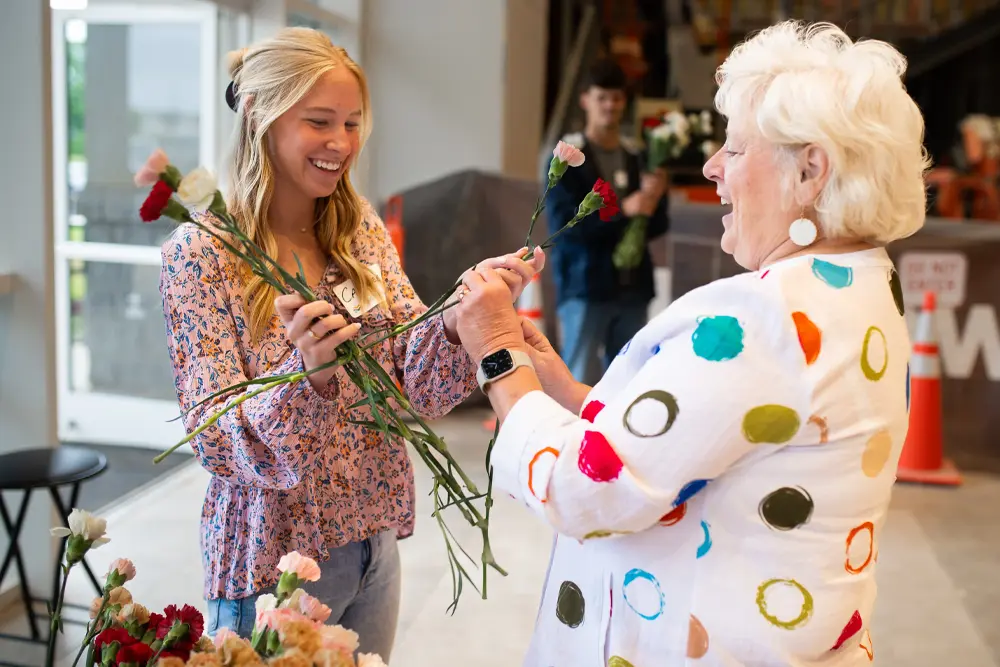 Student girl handing out roses on Mother's Day
