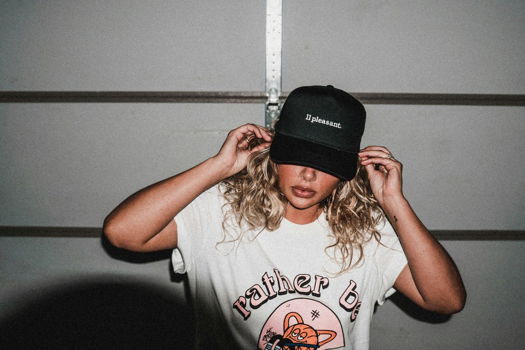 a woman wearing a hat and measuring her hair
