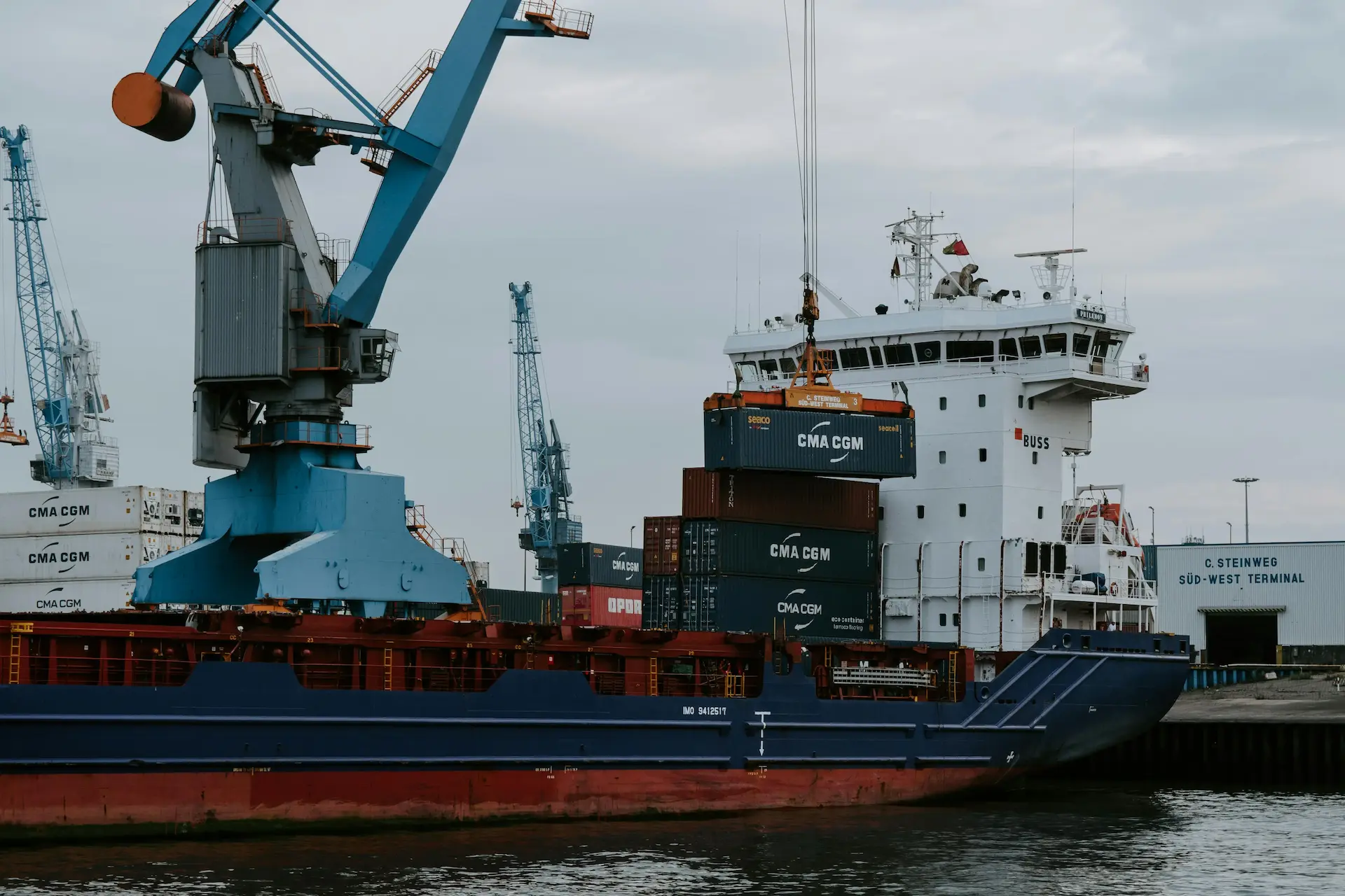 Port crane loading shipping containers onto a cargo vessel