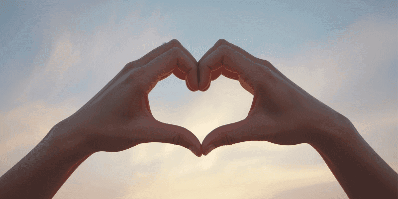 Heart Hands in front of the sky