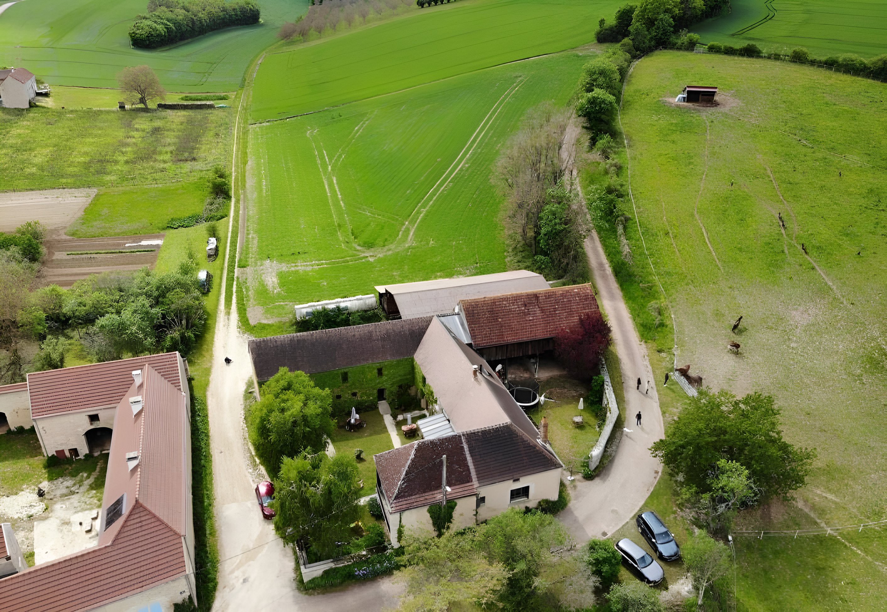 Ferme avec champs verts et bâtiments en briques.