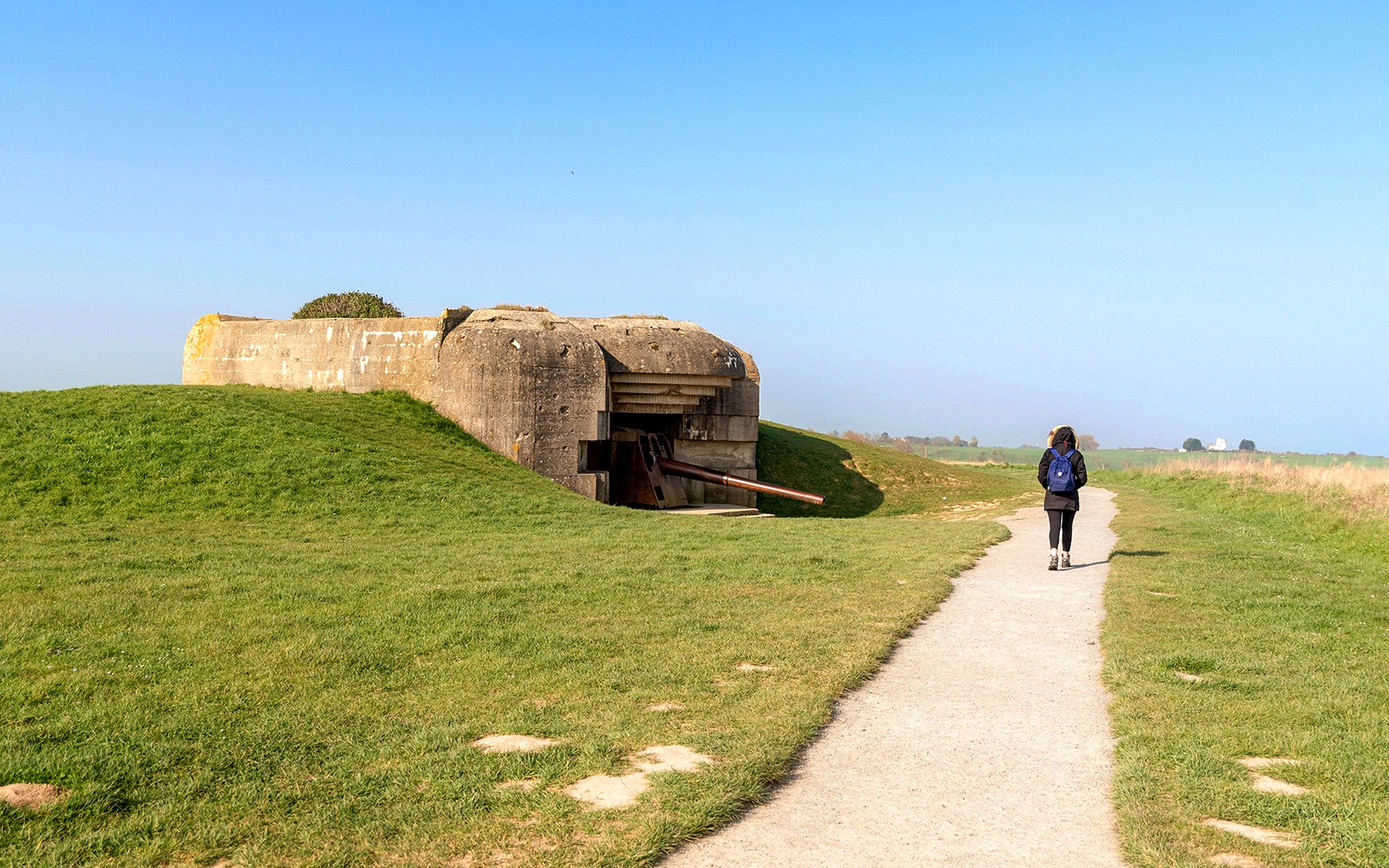 Weg zu einem Weltkriegsbunker in der Normandie, Frankreich, mit einer Person, die spaziert.