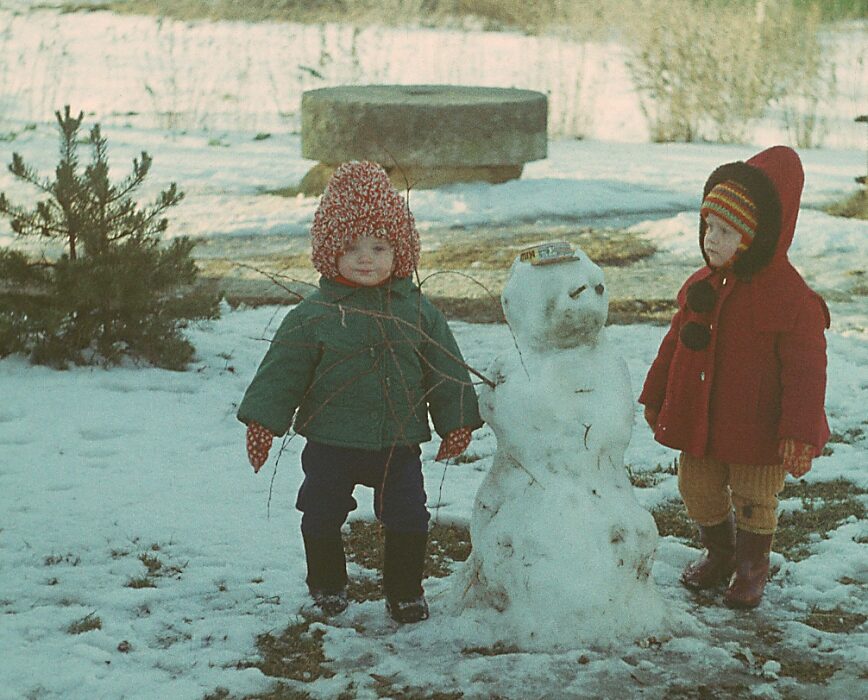 Kaks last soojades riietes talvel lumememme ehitamas