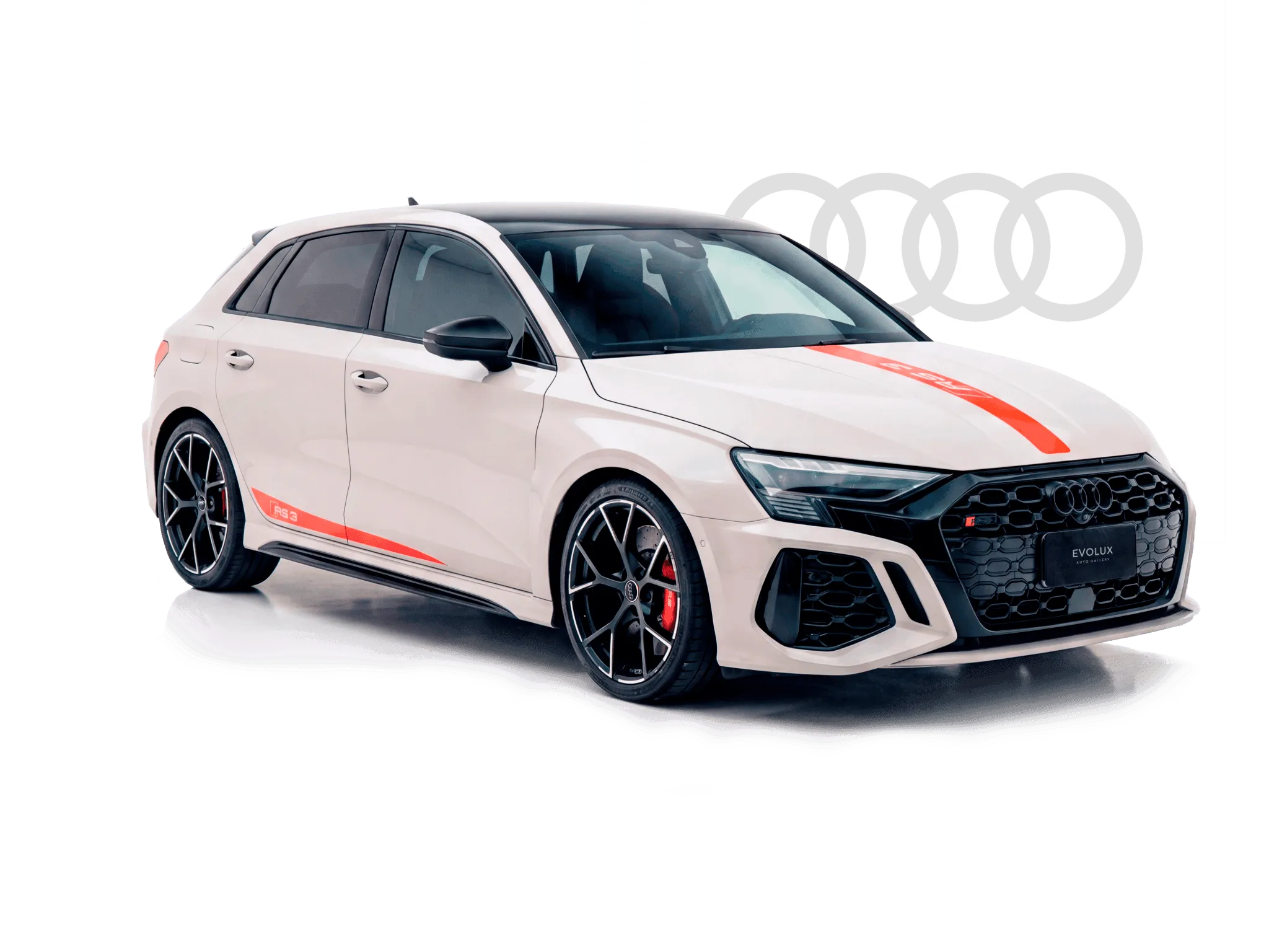 Audi RS3 Sportback blanco con franjas rojas, visto de frente en estudio con el logo de Audi al fondo