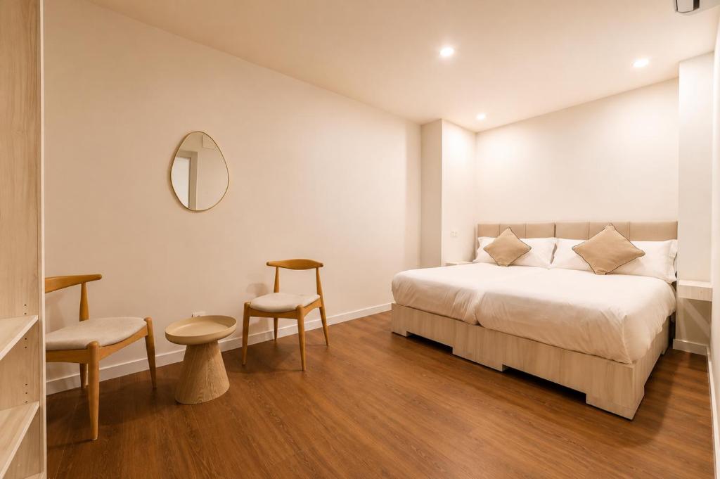 Casa Jazmín Granada: Bedroom with two wood chairs, a round table and a wall mirror
