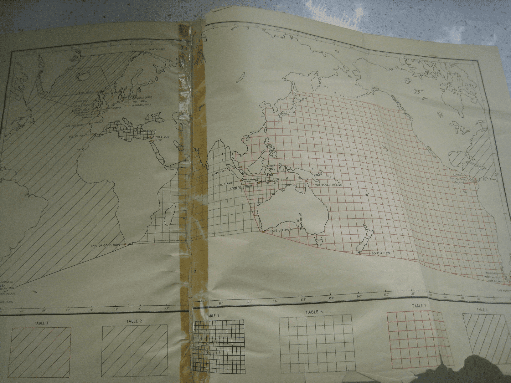 A page from the BP marine distance tables showing the world divided into six tables with connecting waypoints