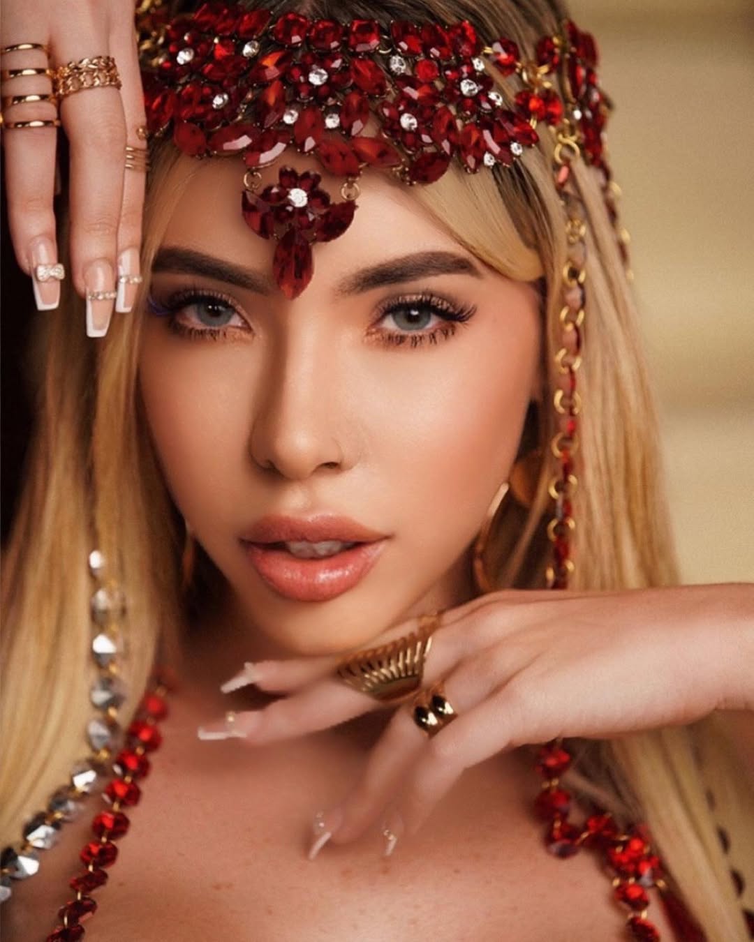 Mujer con vestido negro ajustado y escote pronunciado, posando en un ambiente iluminado con luz púrpura.