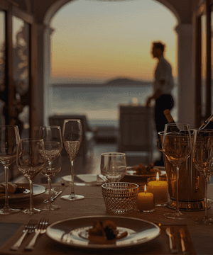 A modern hallway features vibrant teal and orange geometric and leaf patterns, with glossy tiled floors, a large rectangular light fixture, and a small shelf holding a potted plant, all leading to a large, frosted window at the end.