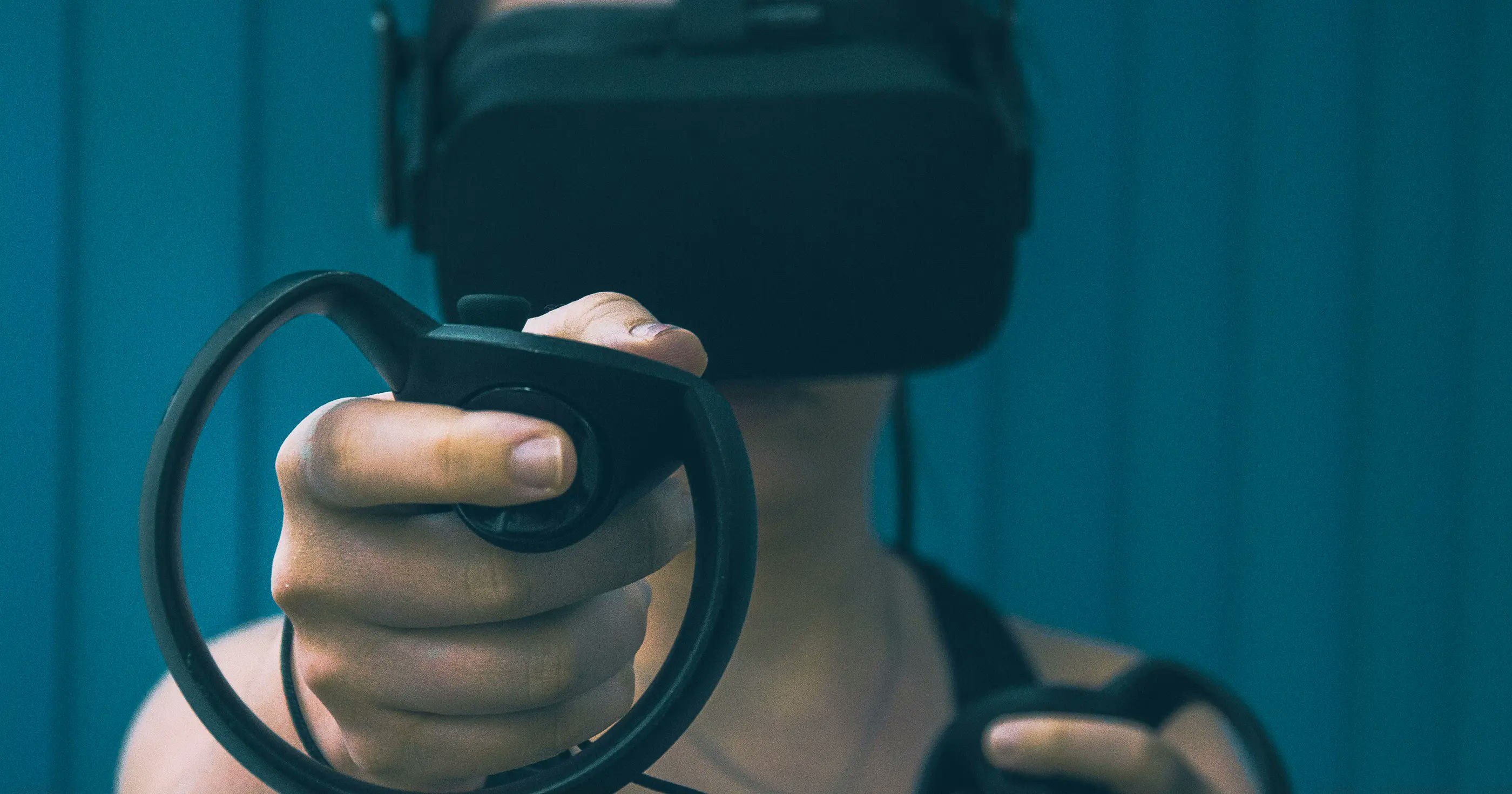 Person using a VR headset and motion controllers, immersed in a virtual reality experience.